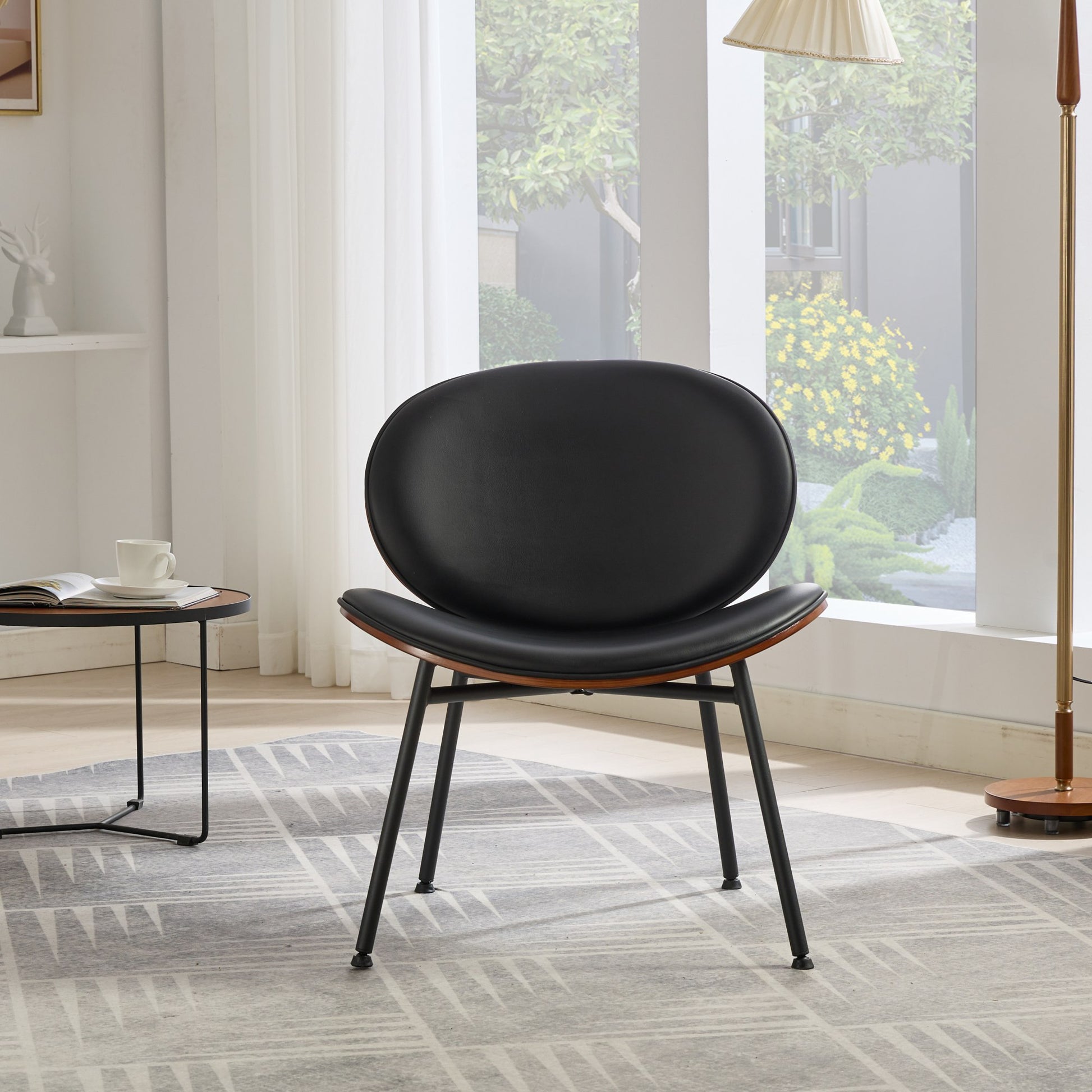 Black leather accent chair with curved walnut veneer seat and black metal legs