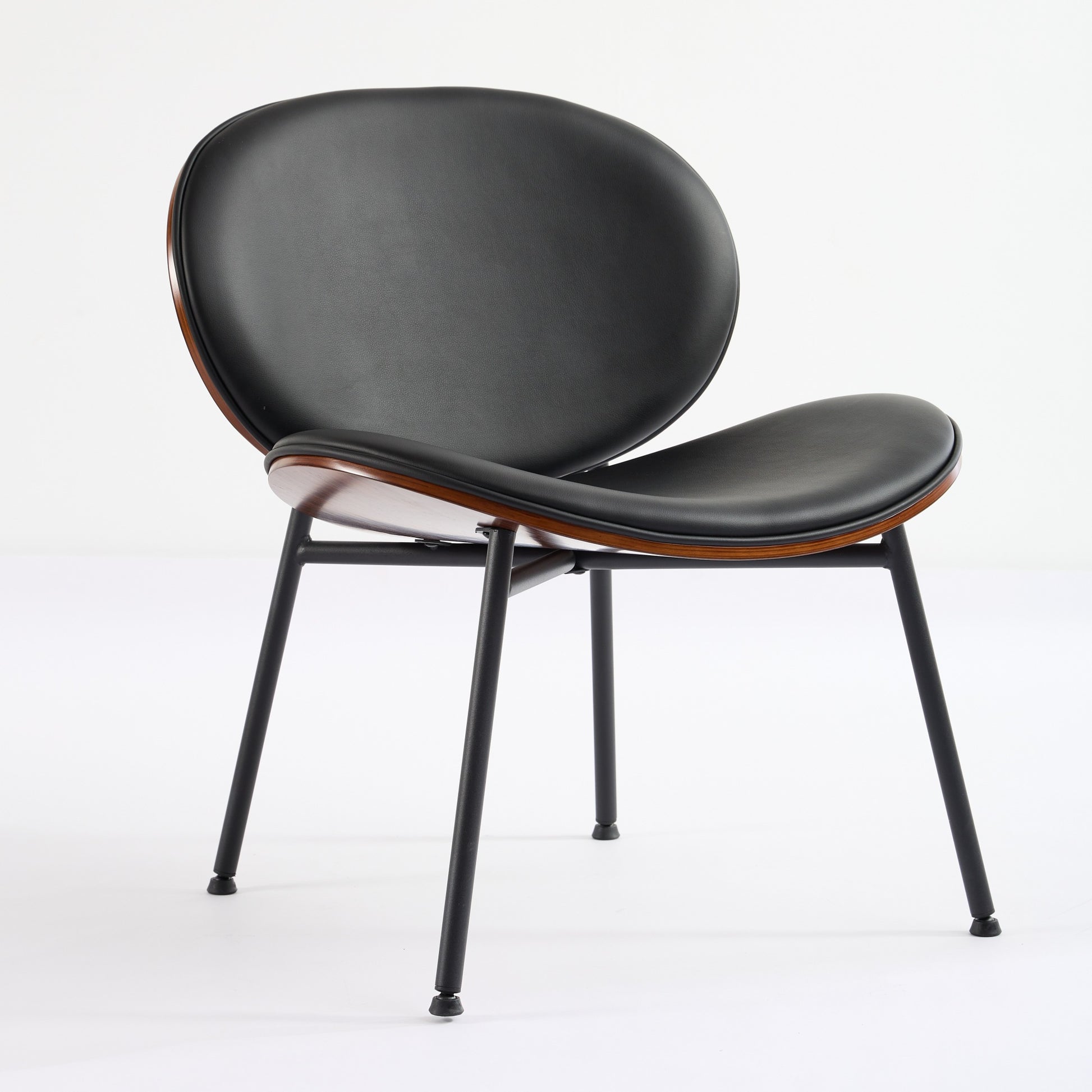 Black leather accent chair with curved wood detail and slender metal legs modern design