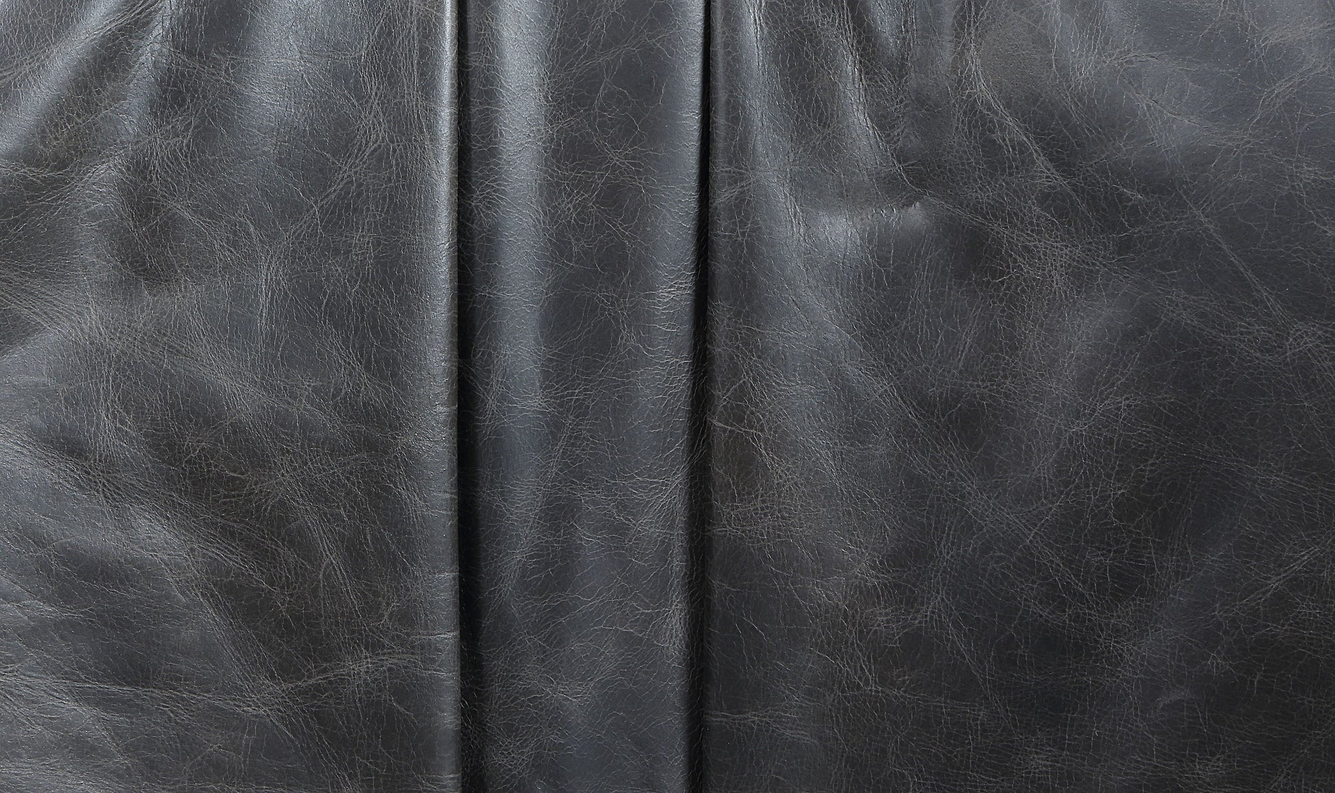Closeup of textured charcoal grey faux leather upholstery material