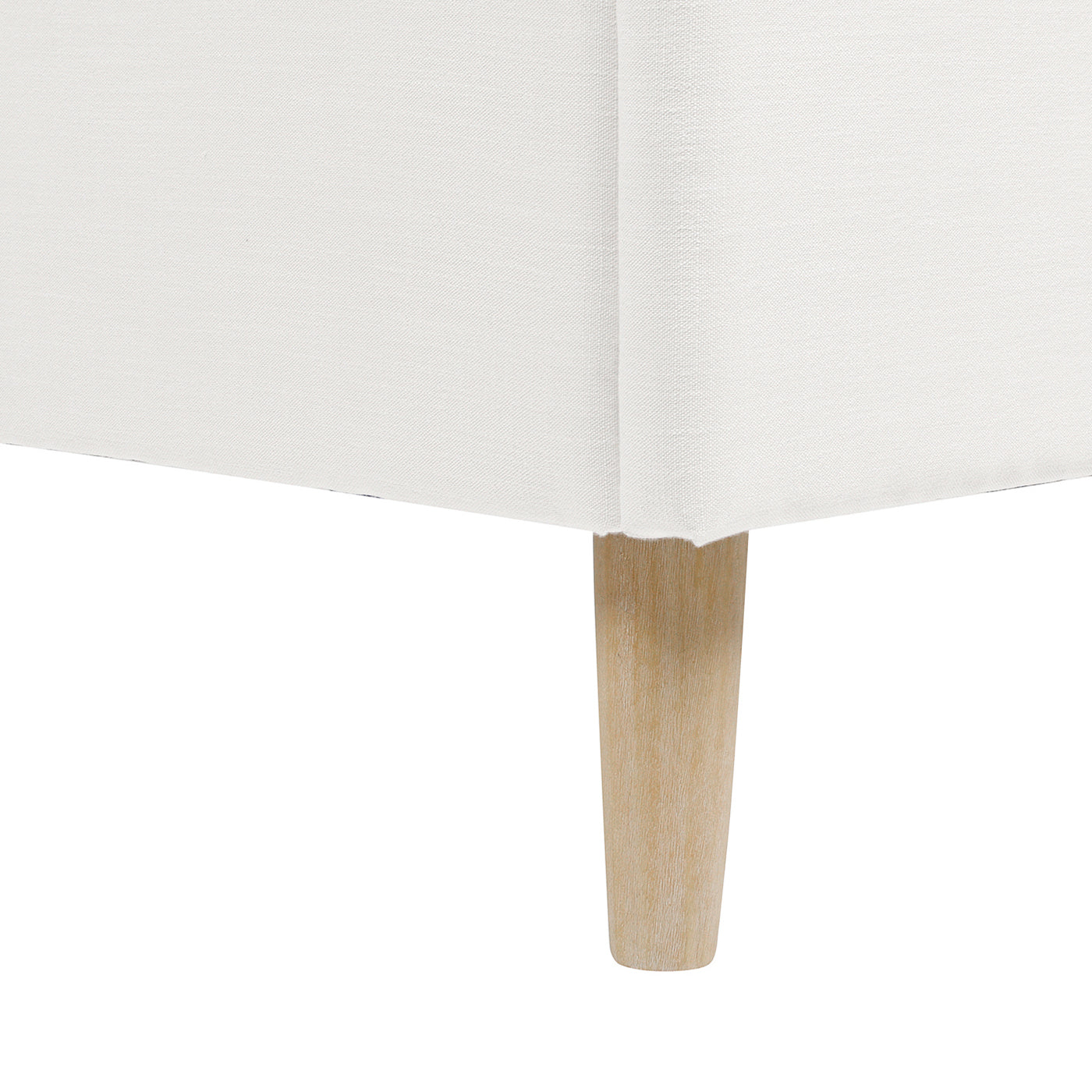White linen sofa base with tapered light wood leg detail
