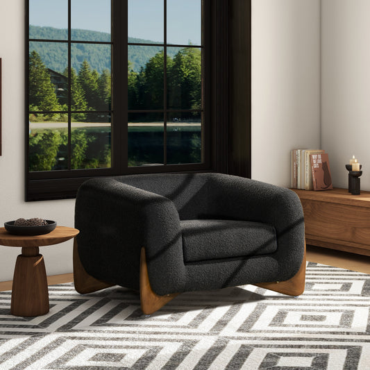 Plush charcoal boucle armchair with flared wooden legs a cozy accent chair for living rooms