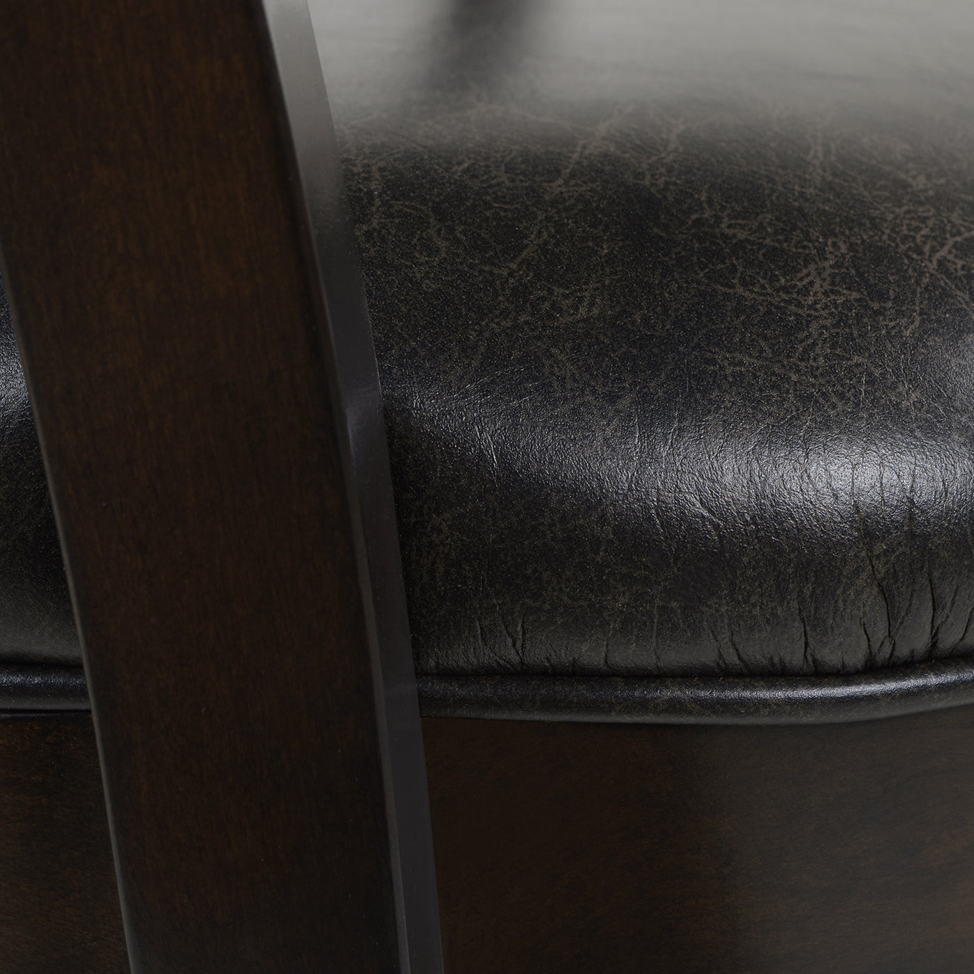 Dark brown distressed faux leather tufted seat cushion on a wooden chair frame