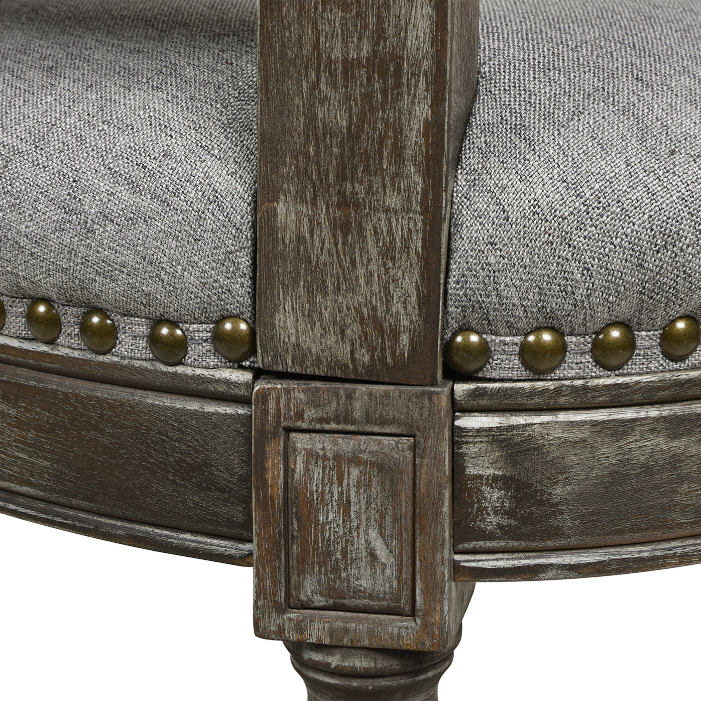 Tufted grey upholstered armchair with distressed dark wood frame and antique brass nailhead trim