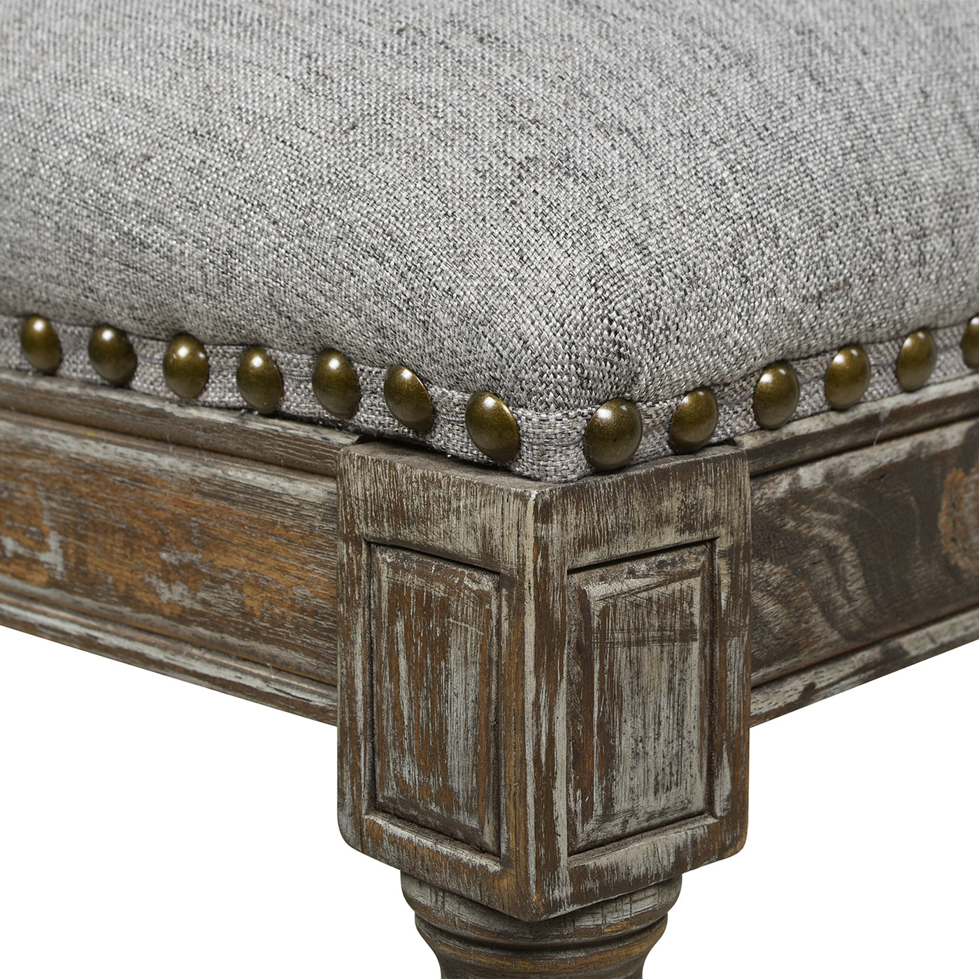 Gray linen upholstered stool with antique brass nailhead trim and distressed wood frame
