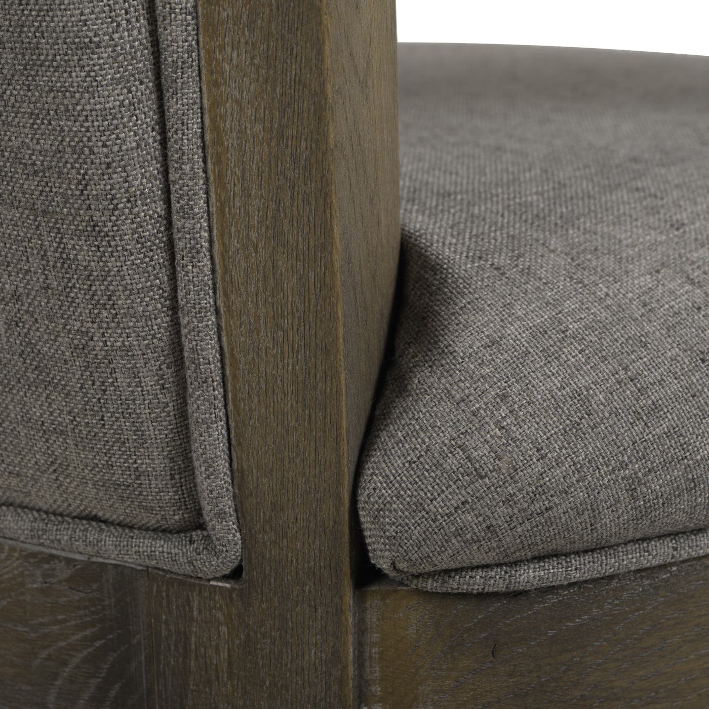 Closeup of a grey upholstered accent chair with a distressed wood frame