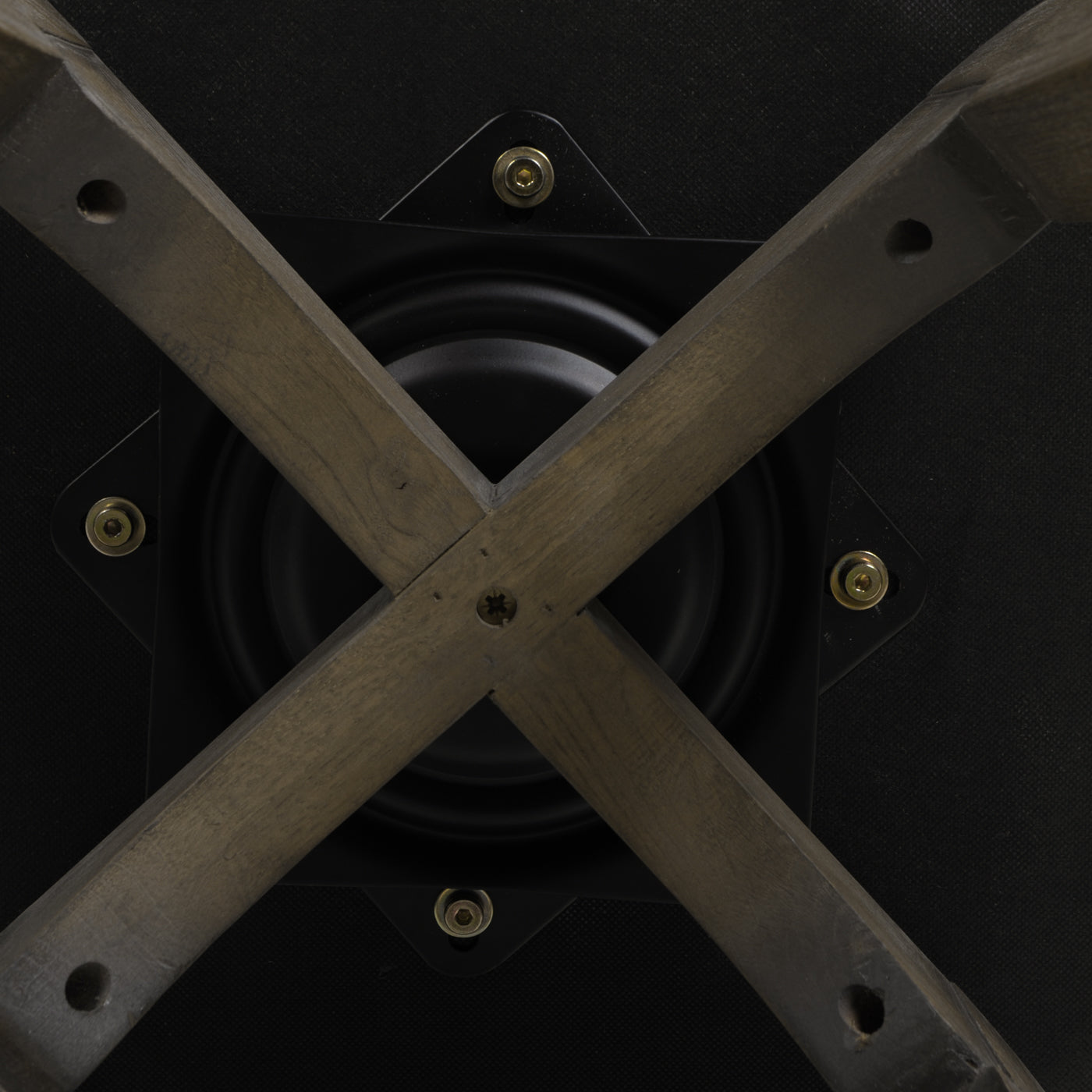 Base of a swivel chair featuring crossed wooden legs and a black metal swivel mechanism