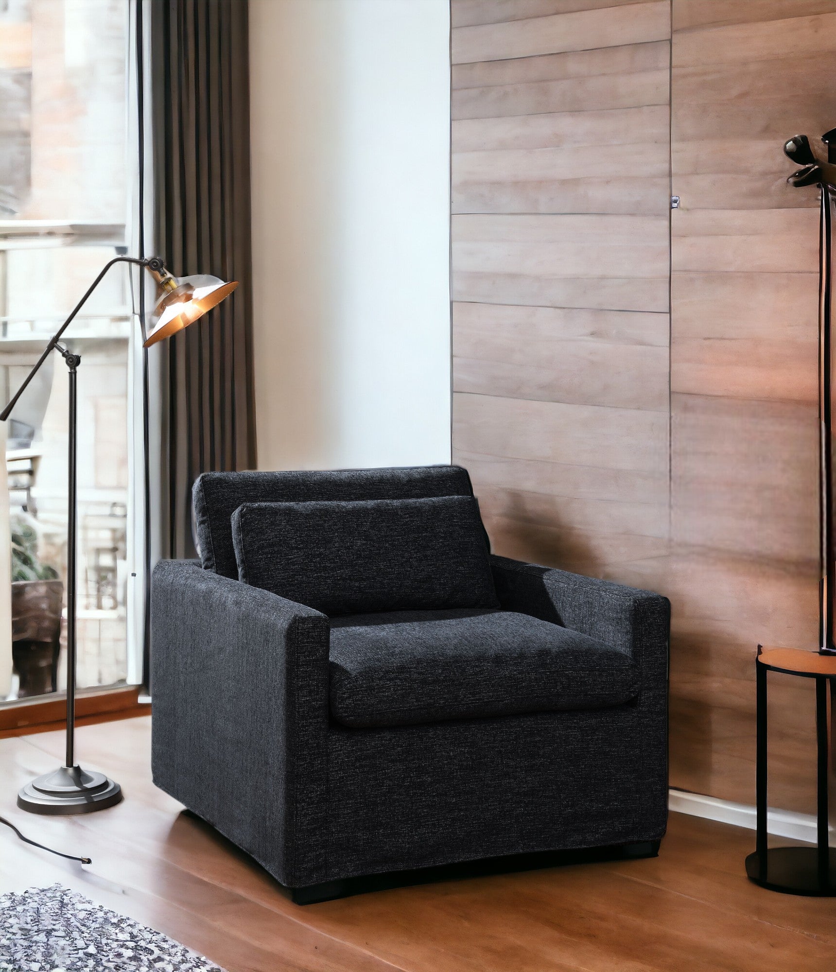 Dark grey textured fabric armchair with a loose back cushion perfect for a modern living room