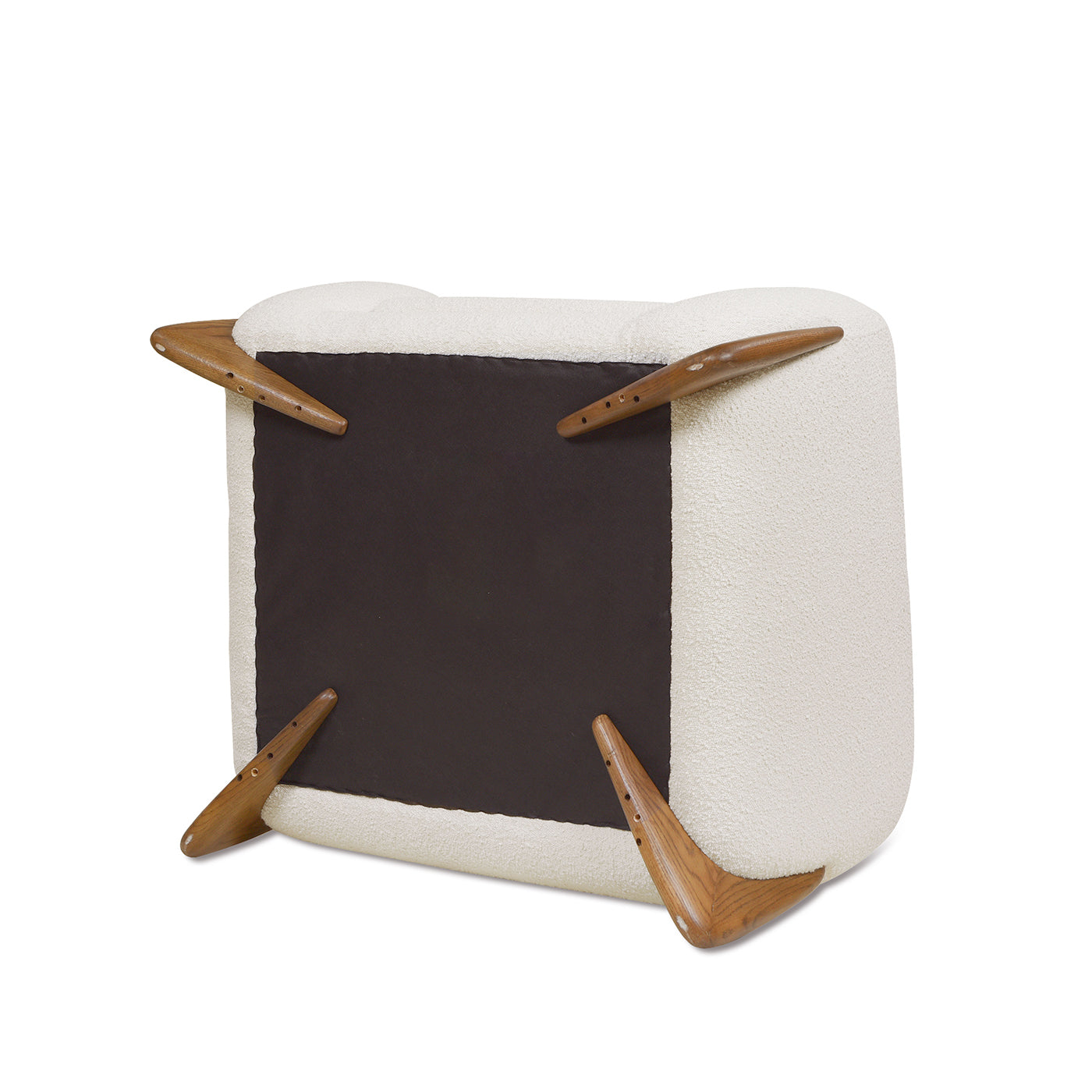 Cream boucle armchair upside down showing tapered wood legs and dark fabric base