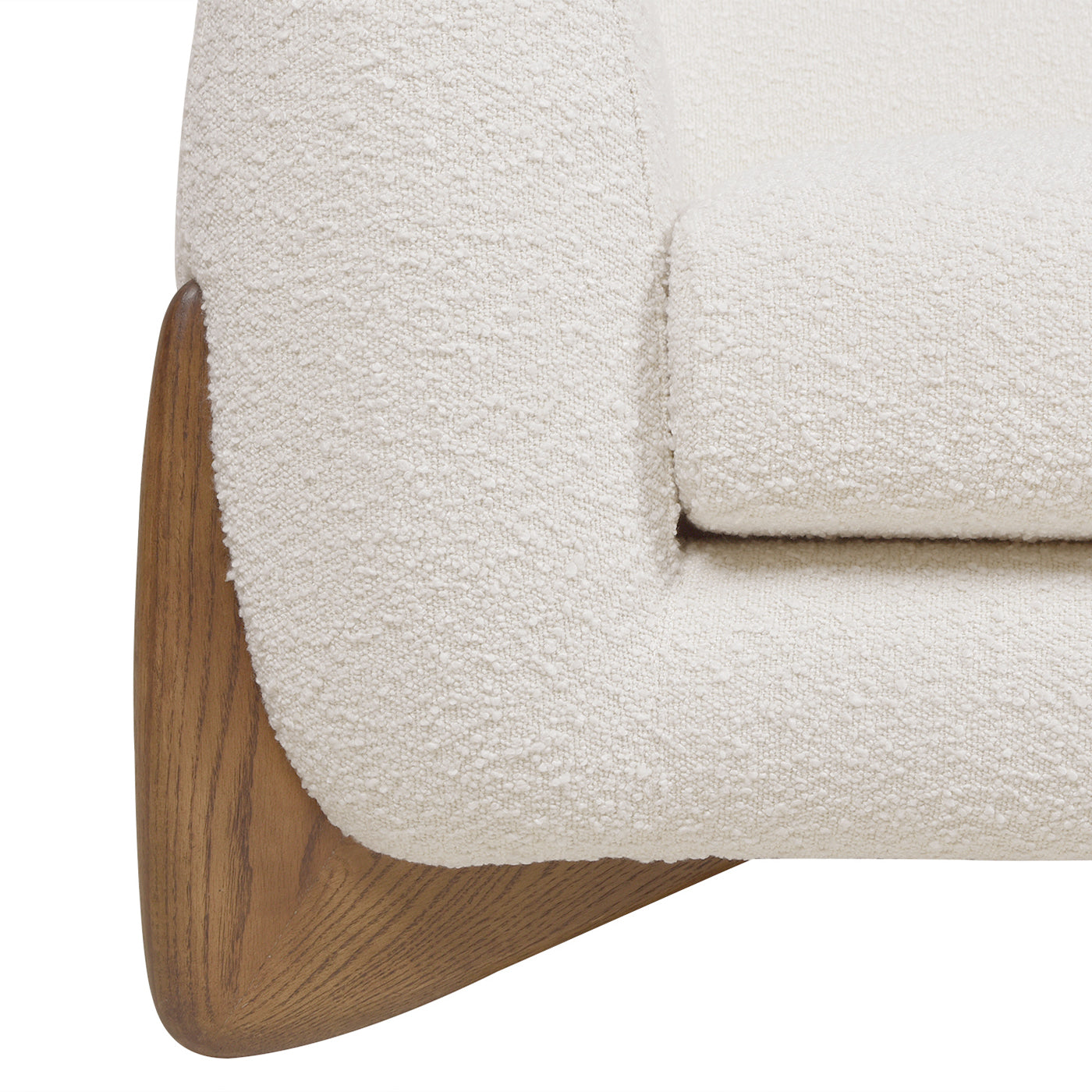 Closeup of textured ivory boucle upholstery on a modern armchair with a curved wooden base