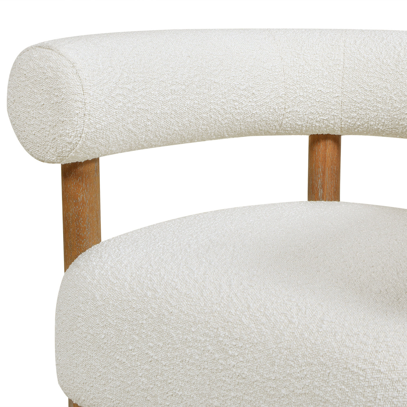 Closeup of a cream boucle upholstered chair with curved back and wooden legs