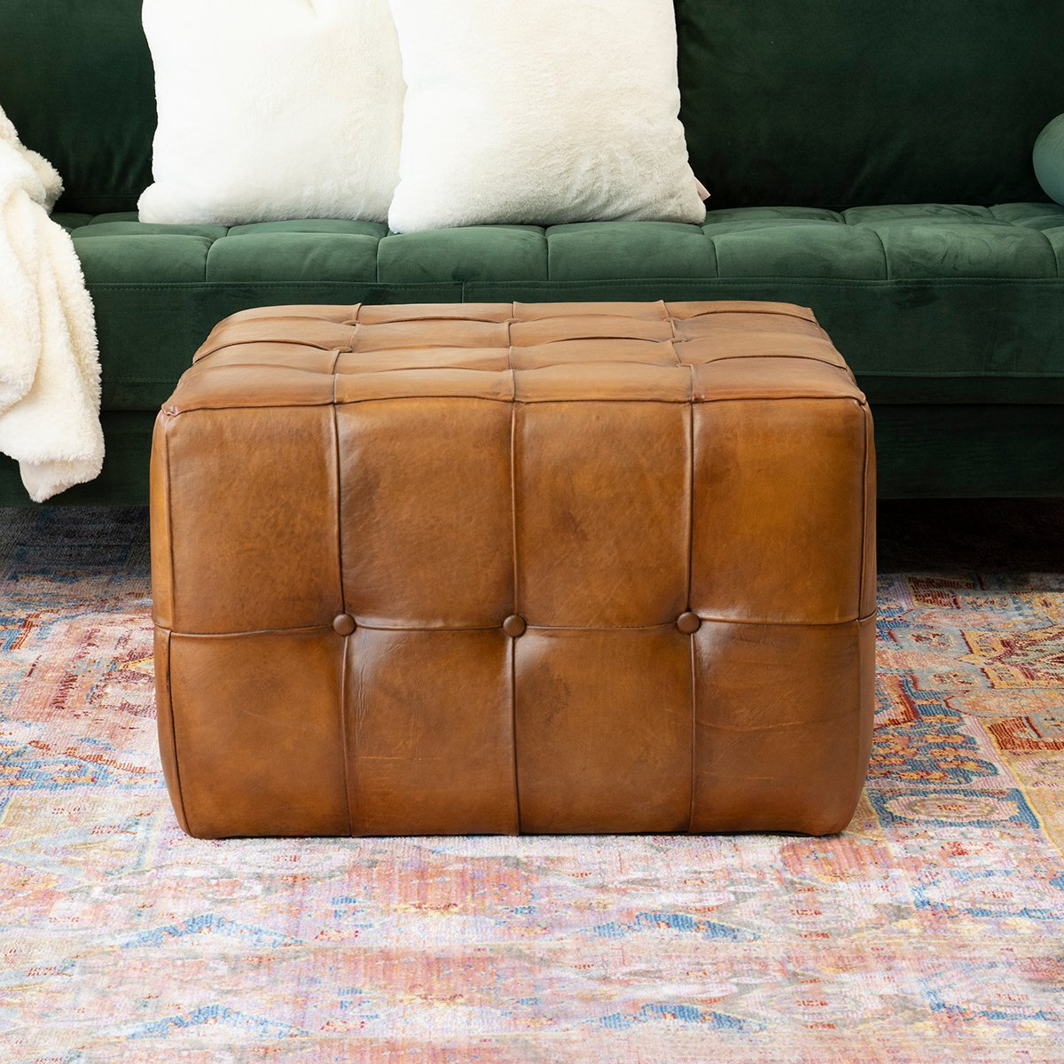 Tufted cognac leather ottoman with button details and a woven texture perfect as a footrest