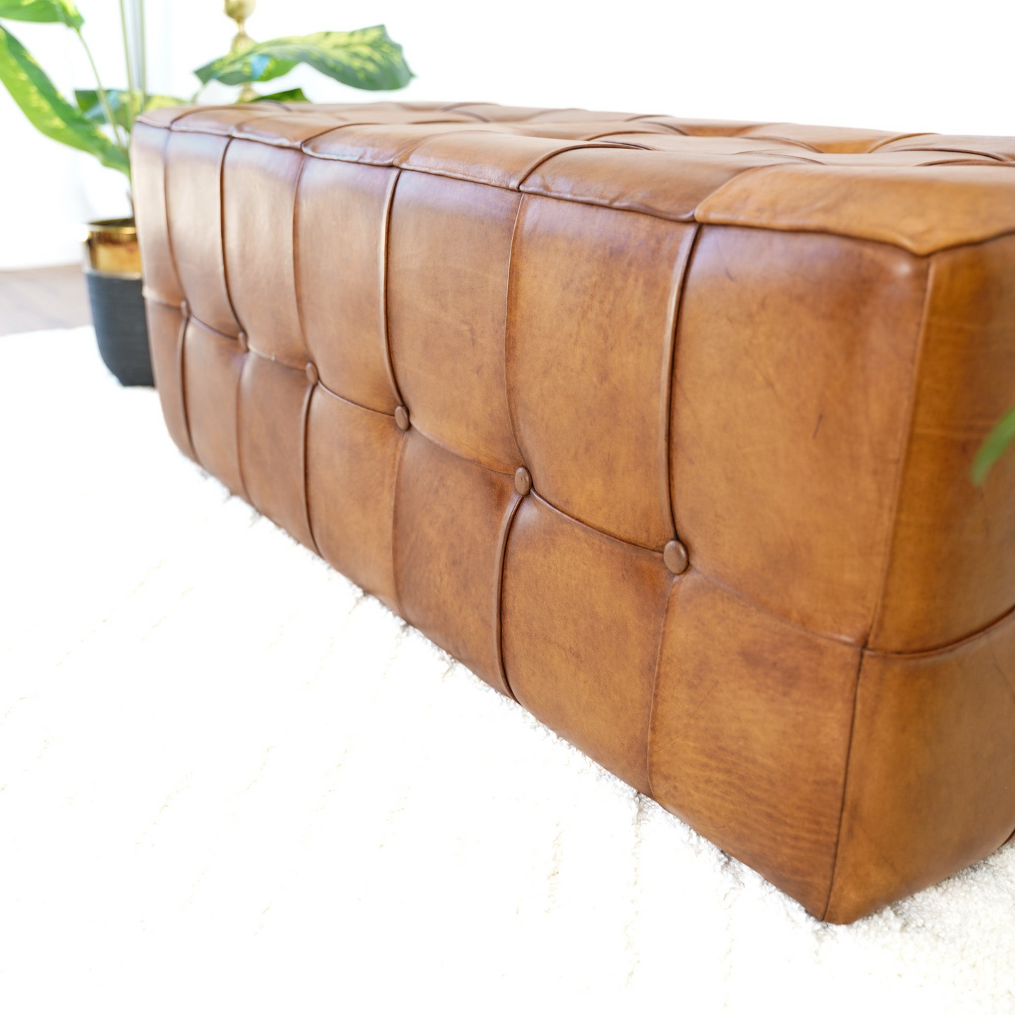 Tufted brown leather ottoman with buttontufting perfect for footrest