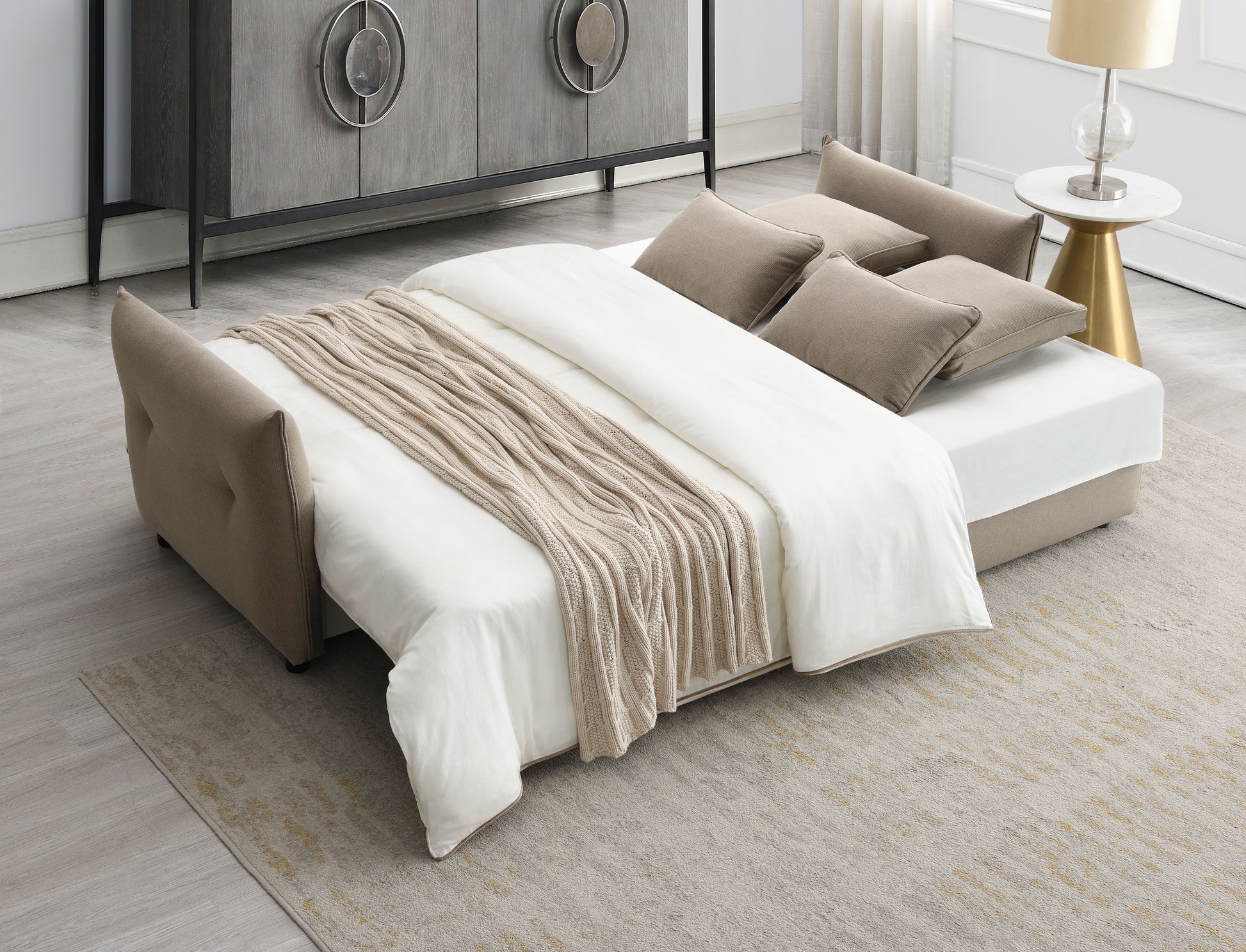 Beige upholstered sofa bed with a white duvet and beige throw blanket  chars