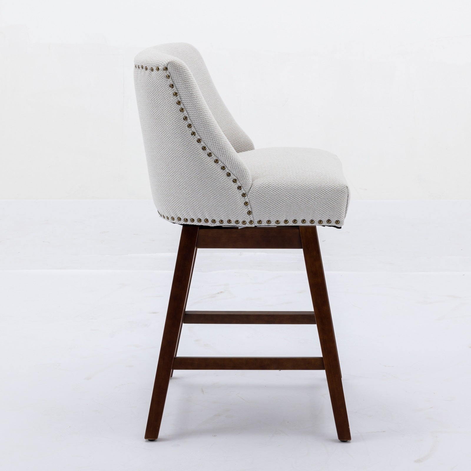 Light gray fabric counter stool with nailhead trim and dark wood legs