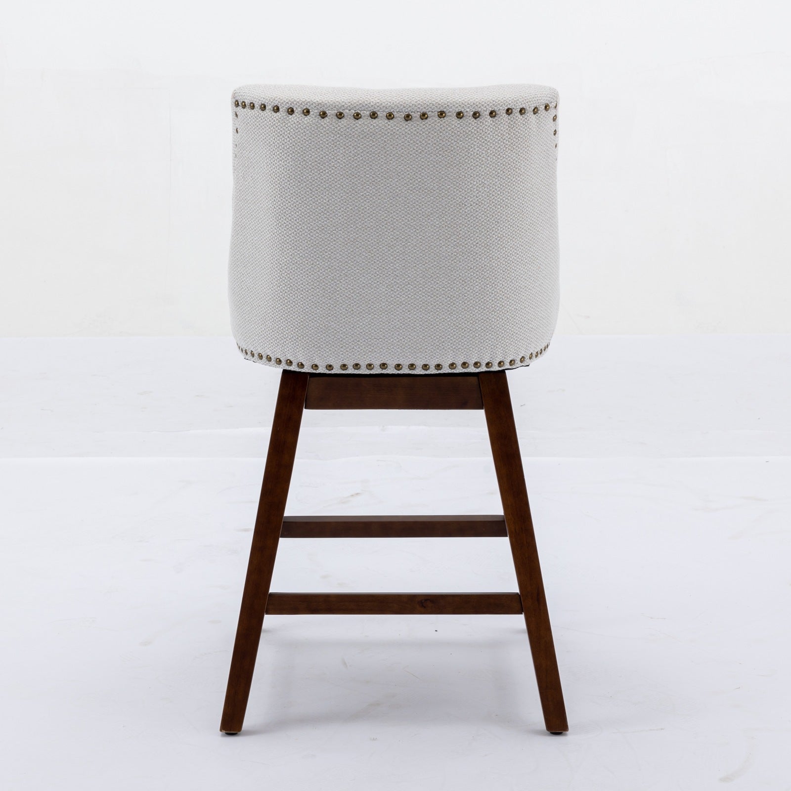 Light gray fabric bar stool with nailhead trim and dark wood legs