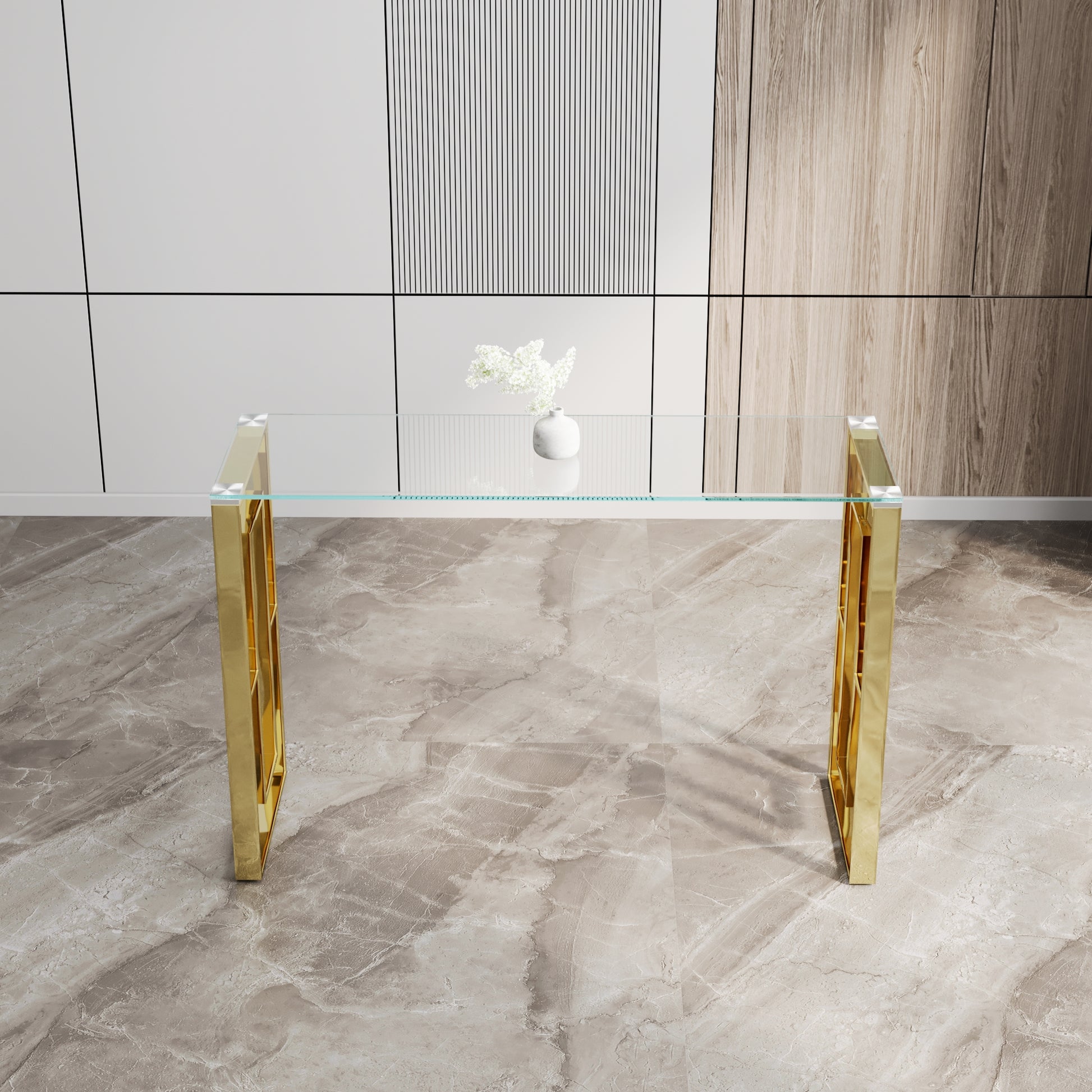 Modern clear glass console table with a polished gold metal frame and geometric legs
