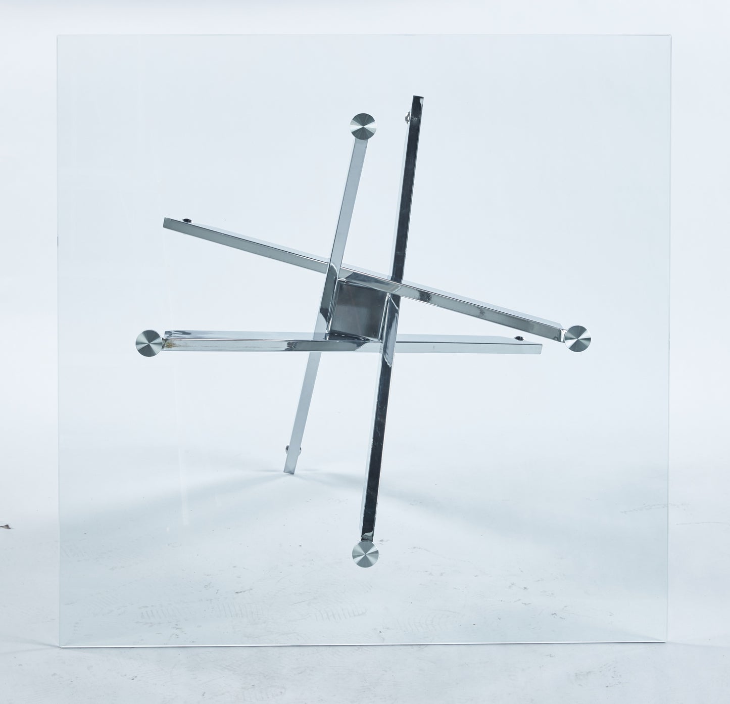 Modern glass top coffee table with a striking chrome star base for a contemporary living room
