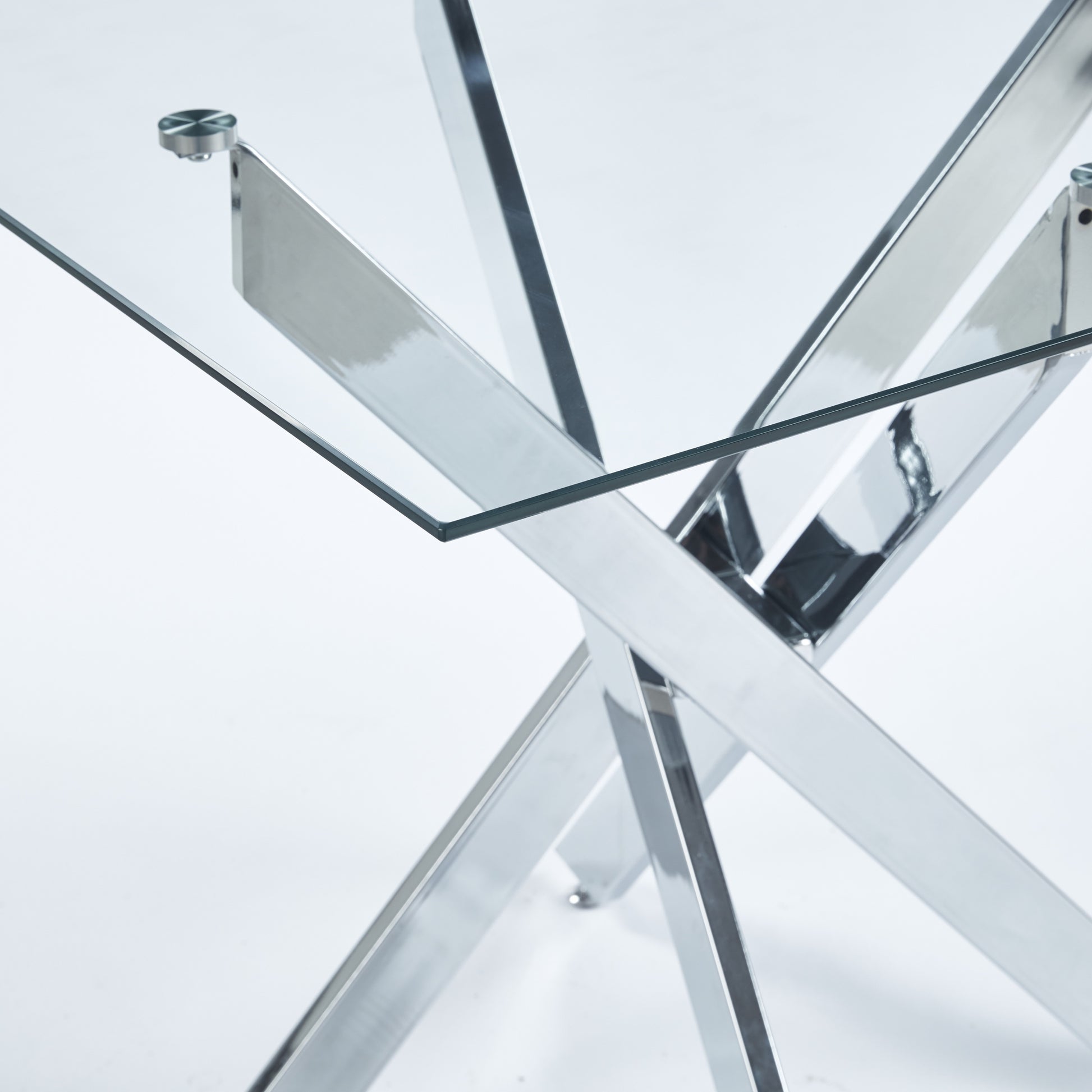 Closeup of a modern glass dining table with a chrome crisscross base