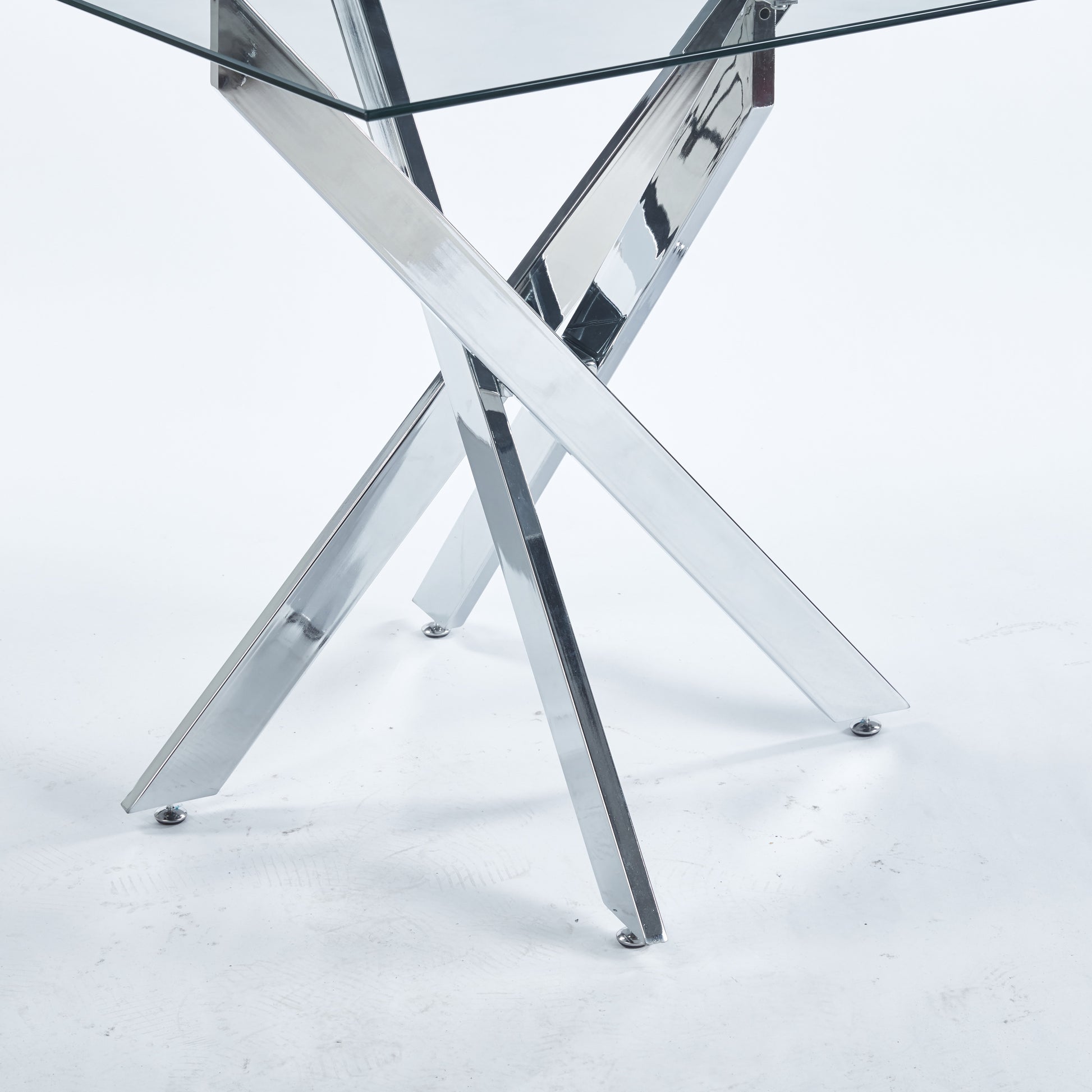 Modern dining table with clear glass top and polished chrome Xbase legs