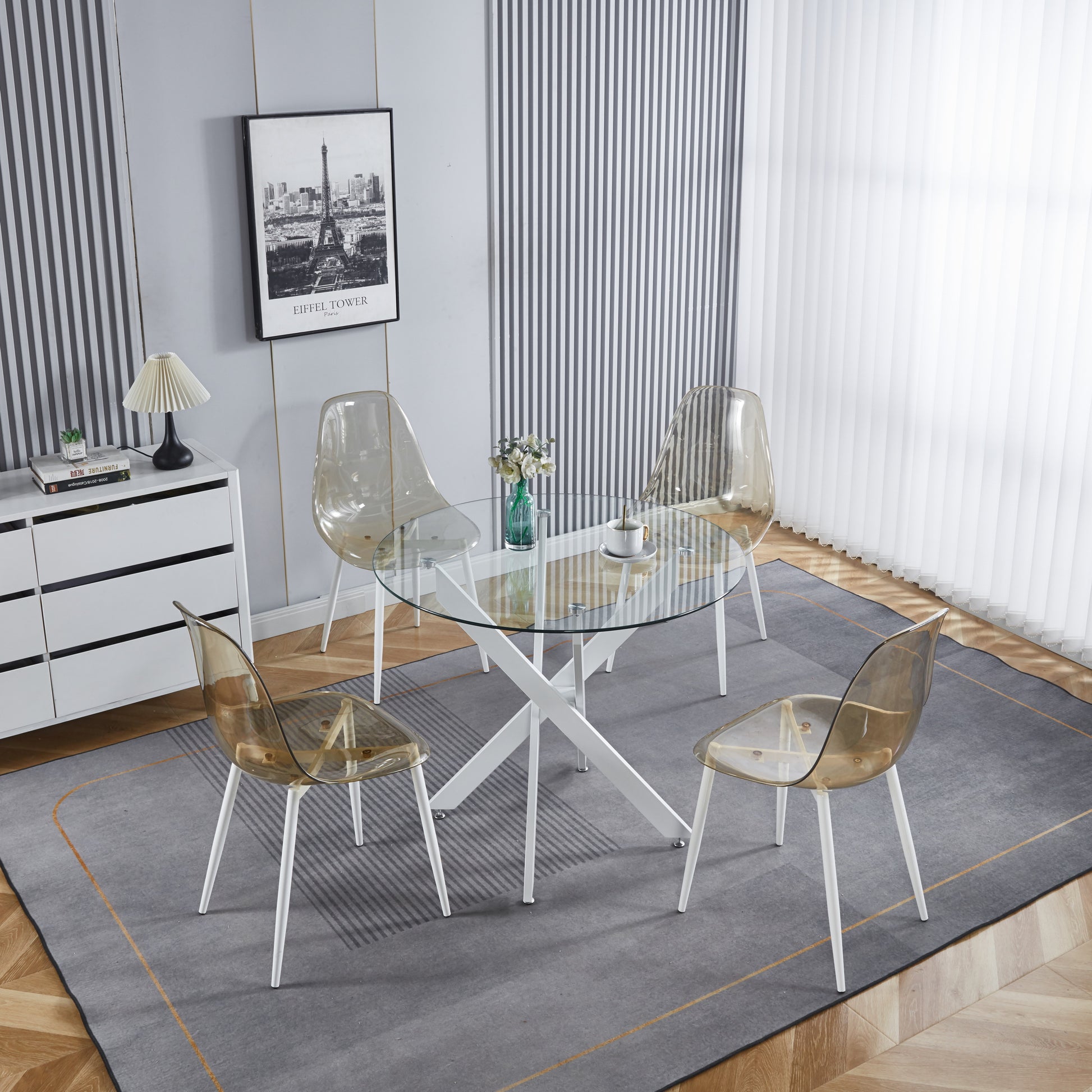 Glass top dining table with white Xframe base and four translucent amber chairs