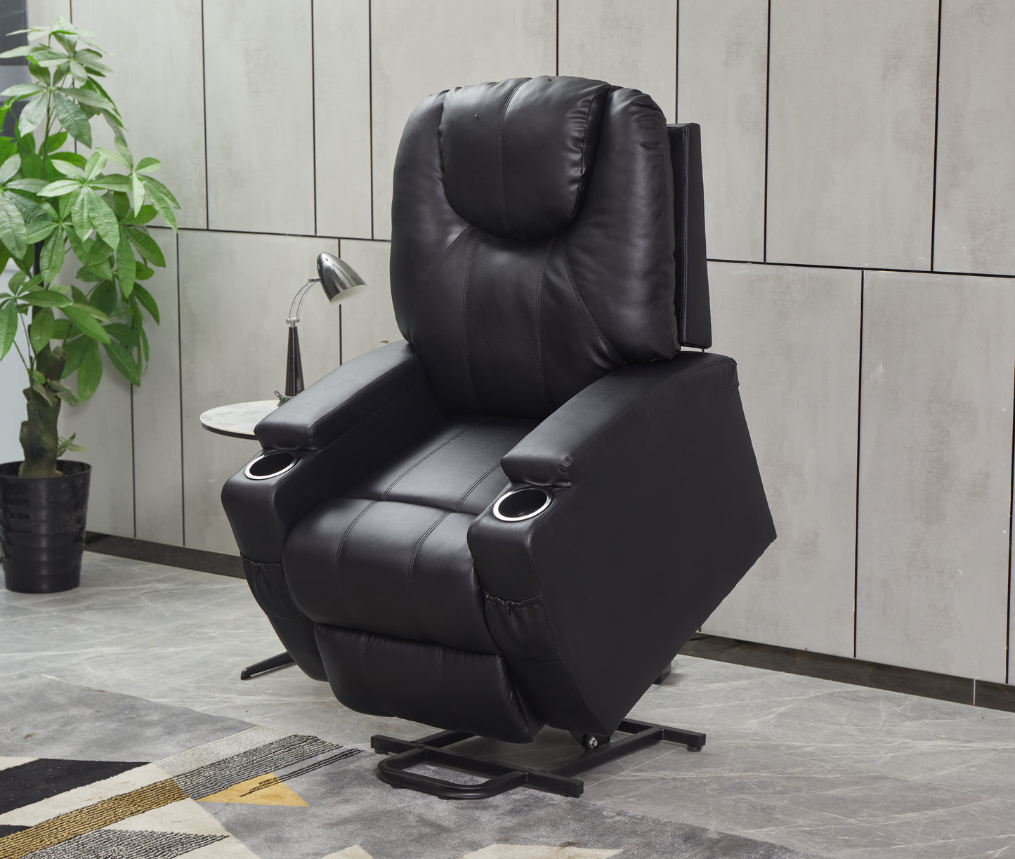 Black leather recliner chair with padded headrest and integrated cup holders
