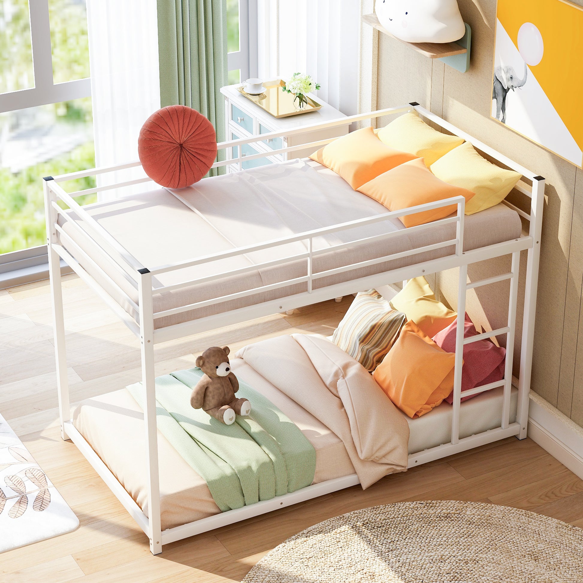 White metal twin over twin bunk bed with colorful pillows and a teddy bear