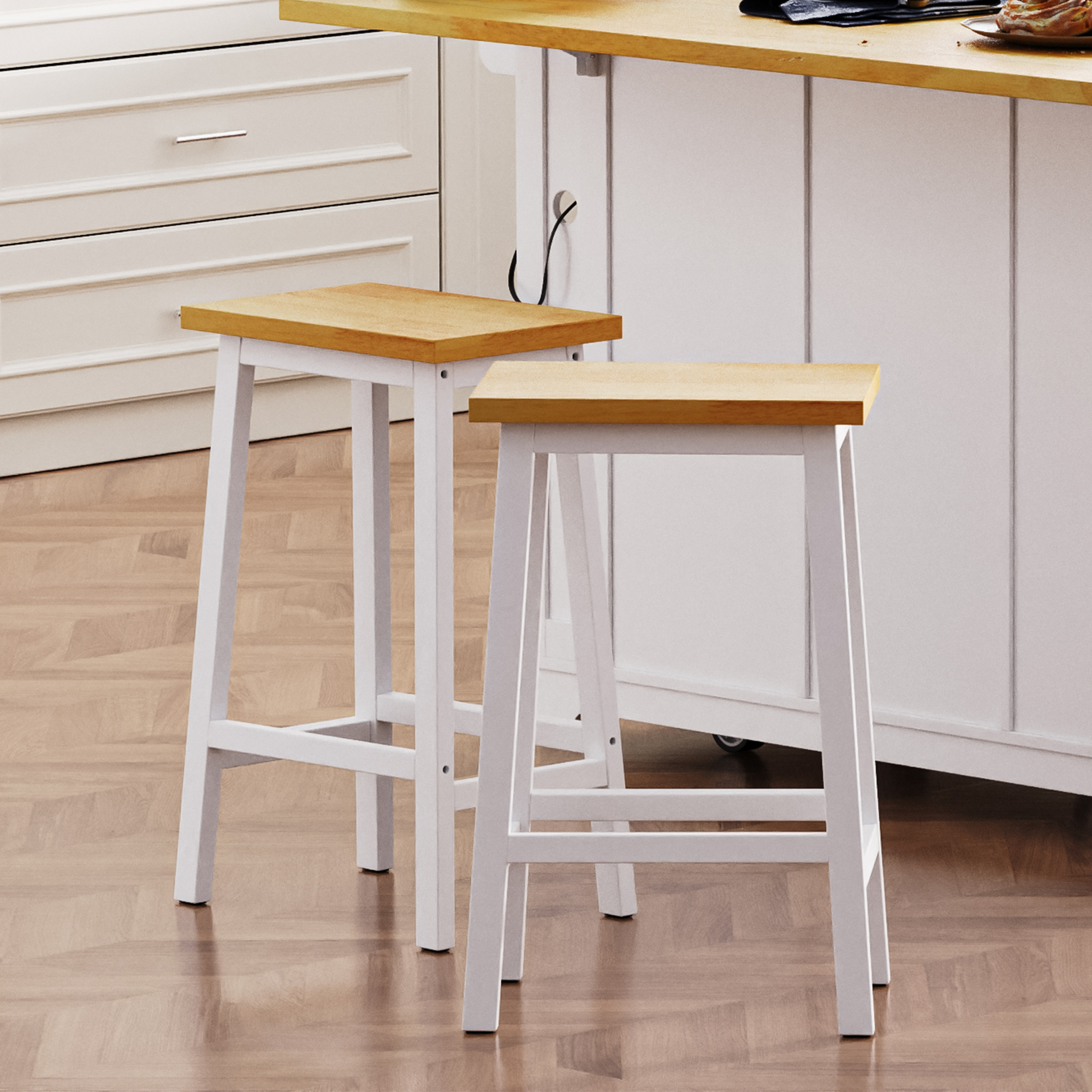 Two white wooden bar stools with natural wood seats placed near a kitchen island