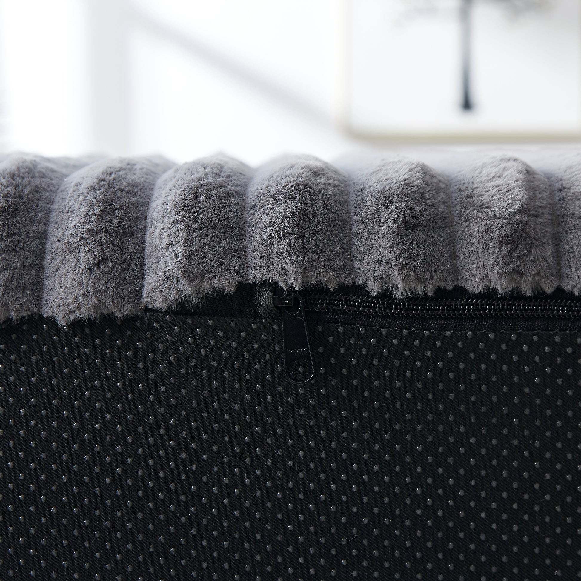 Plush grey dog bed with textured surface and zipper detail