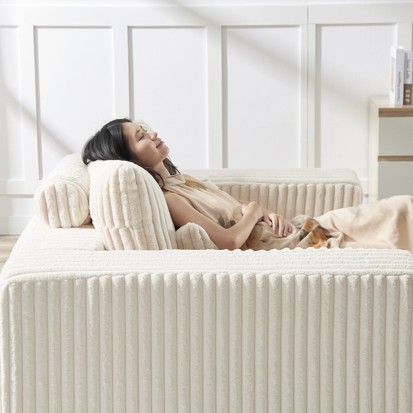 Plush cream corduroy sofa with a woman relaxing on it offering ultimate comfort