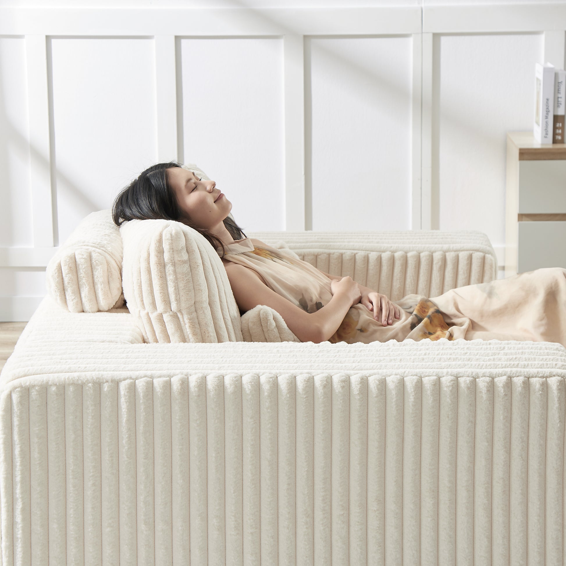 Plush cream corduroy sofa with a woman relaxing on it offering ultimate comfort