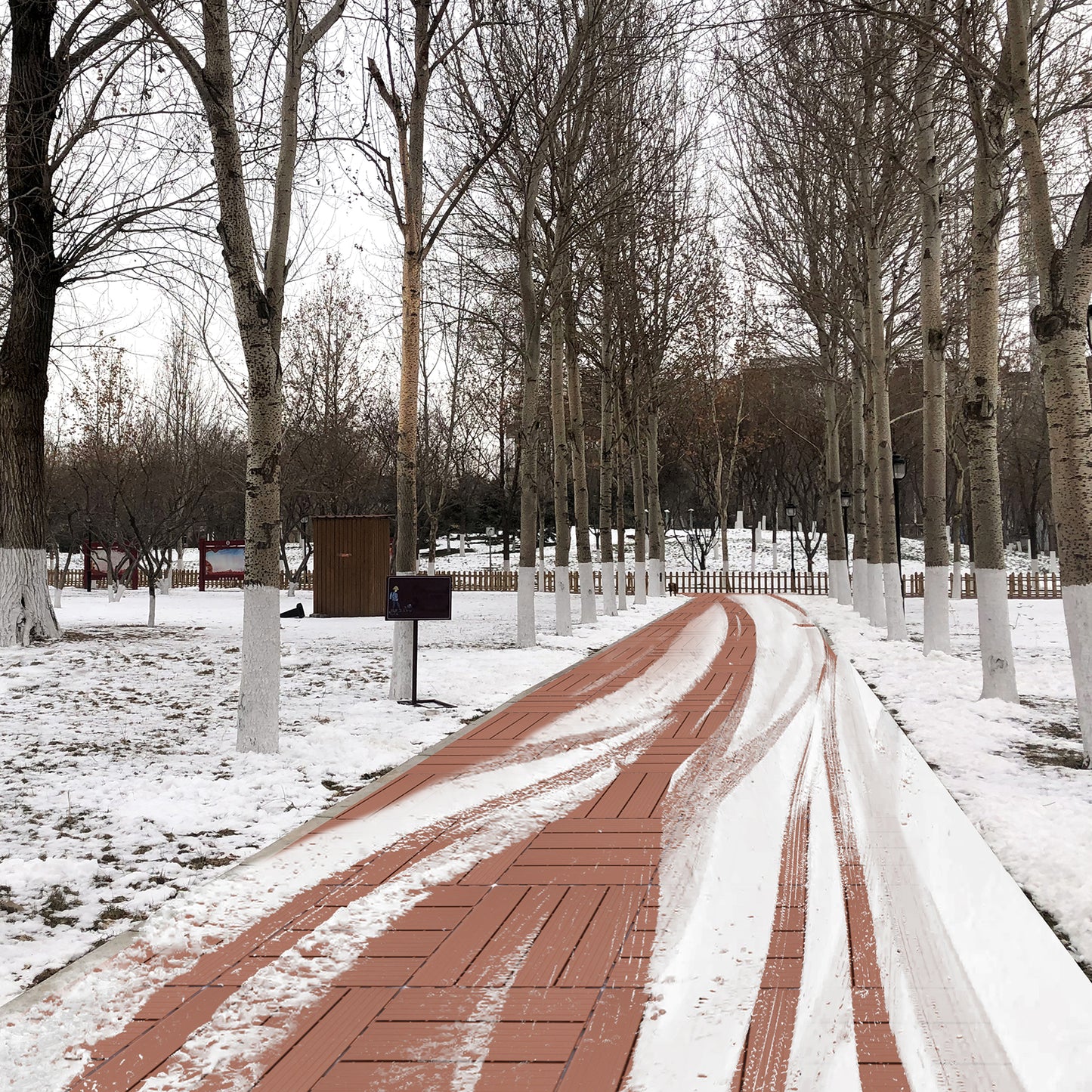 Red brick walkway with snow tracks in a winter park setting