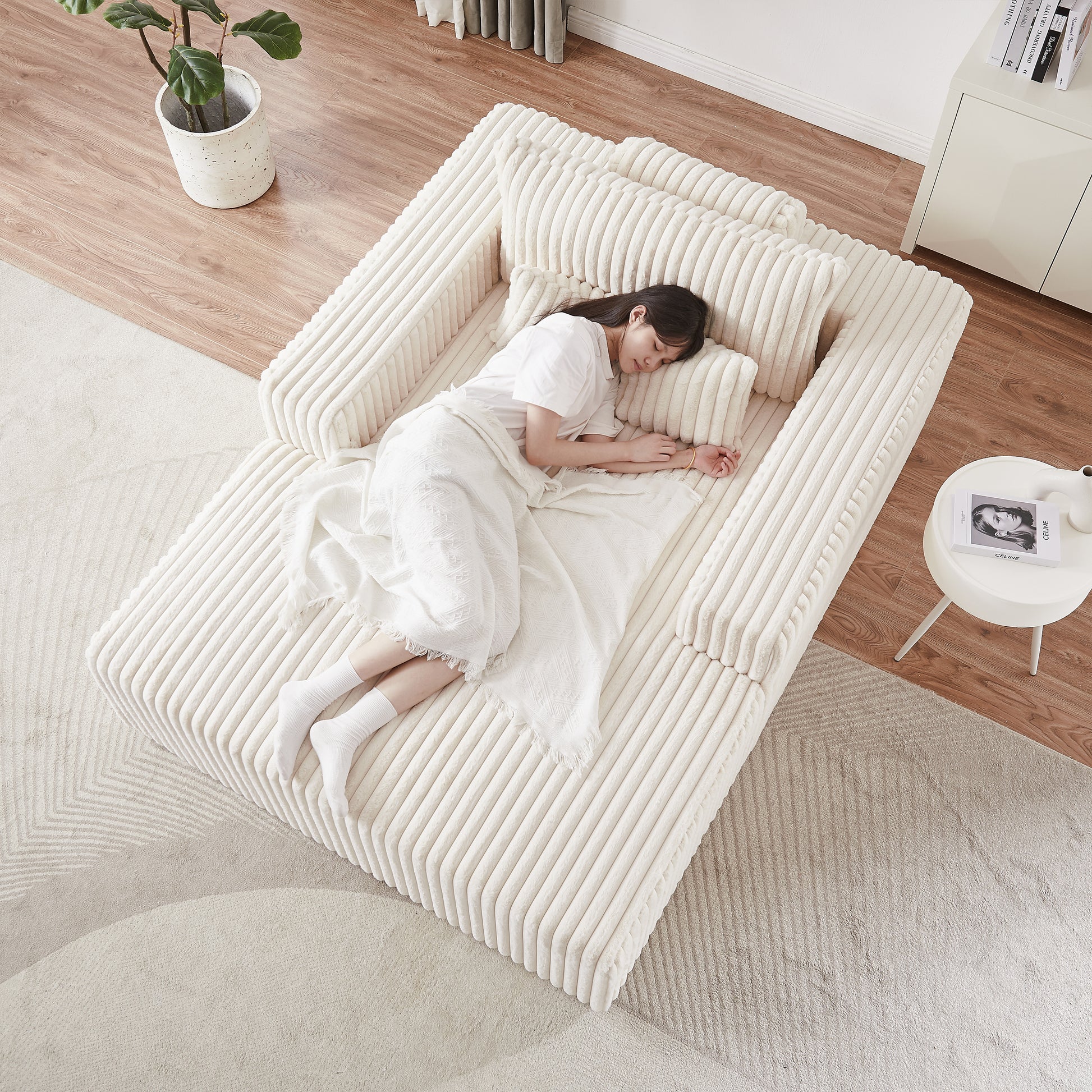 Cream corduroy modular sofa with plush cushions and a sleeping woman