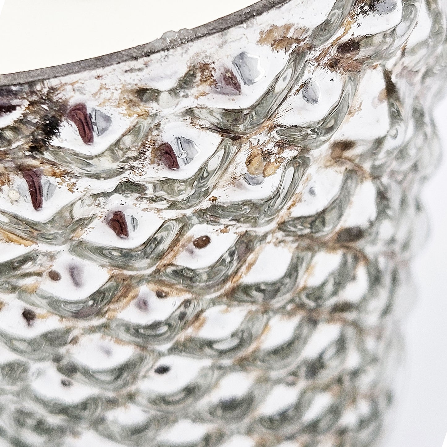 Closeup of a textured mercury glass vase with a metallic sheen