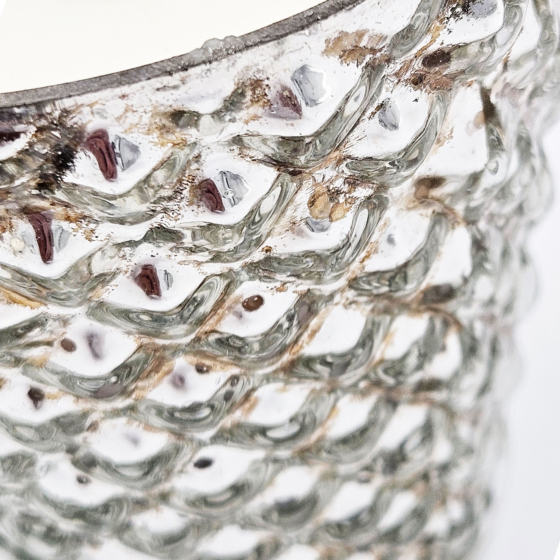 Closeup of a textured mercury glass vase with a metallic sheen