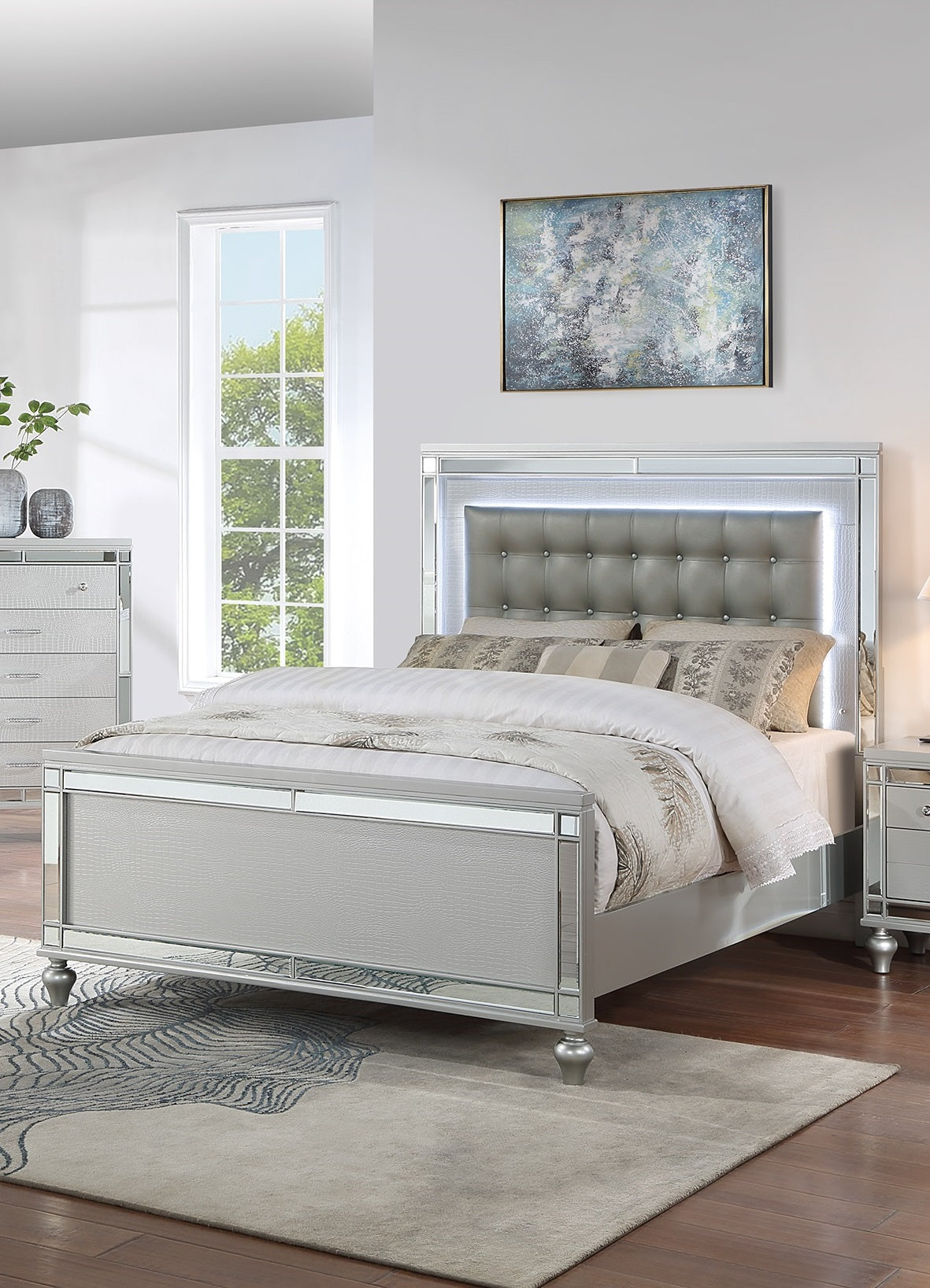 Silver tufted upholstered queen bed with mirrored trim and LED lighting