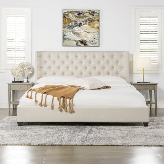 Cream upholstered platform bed with tufted headboard and camel throw blanket