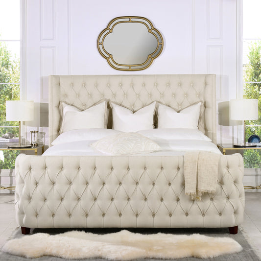 Tufted beige upholstered bed with diamond tufting crisp white bedding and decorative pillows