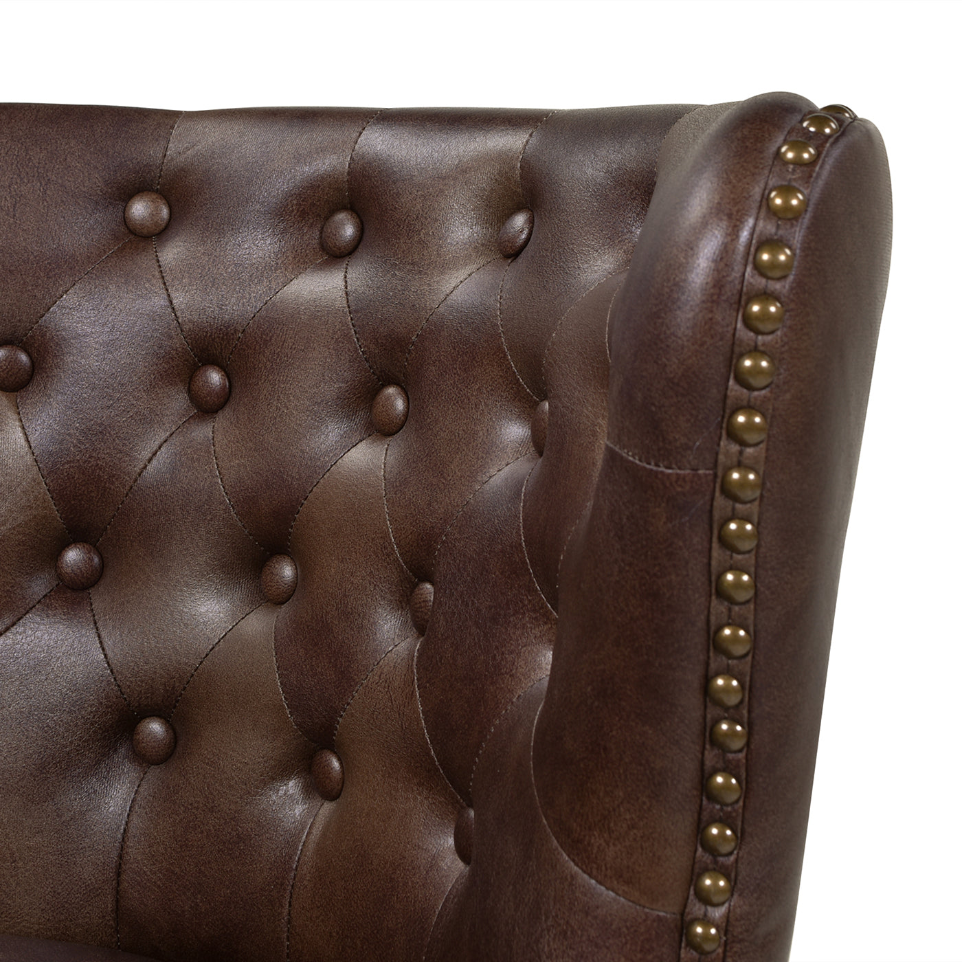 Brown tufted leather armchair detail with brass nailhead trim