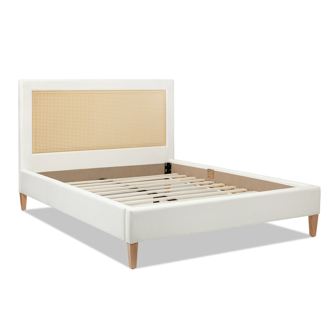 White linen upholstered bed frame with cane headboard and natural wood legs