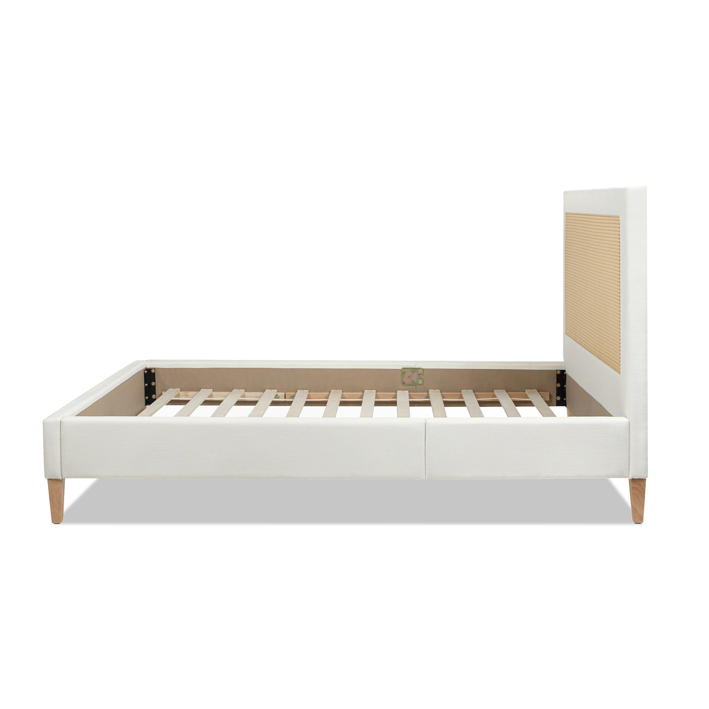 White linen upholstered platform bed frame with natural wood slats and cane headboard