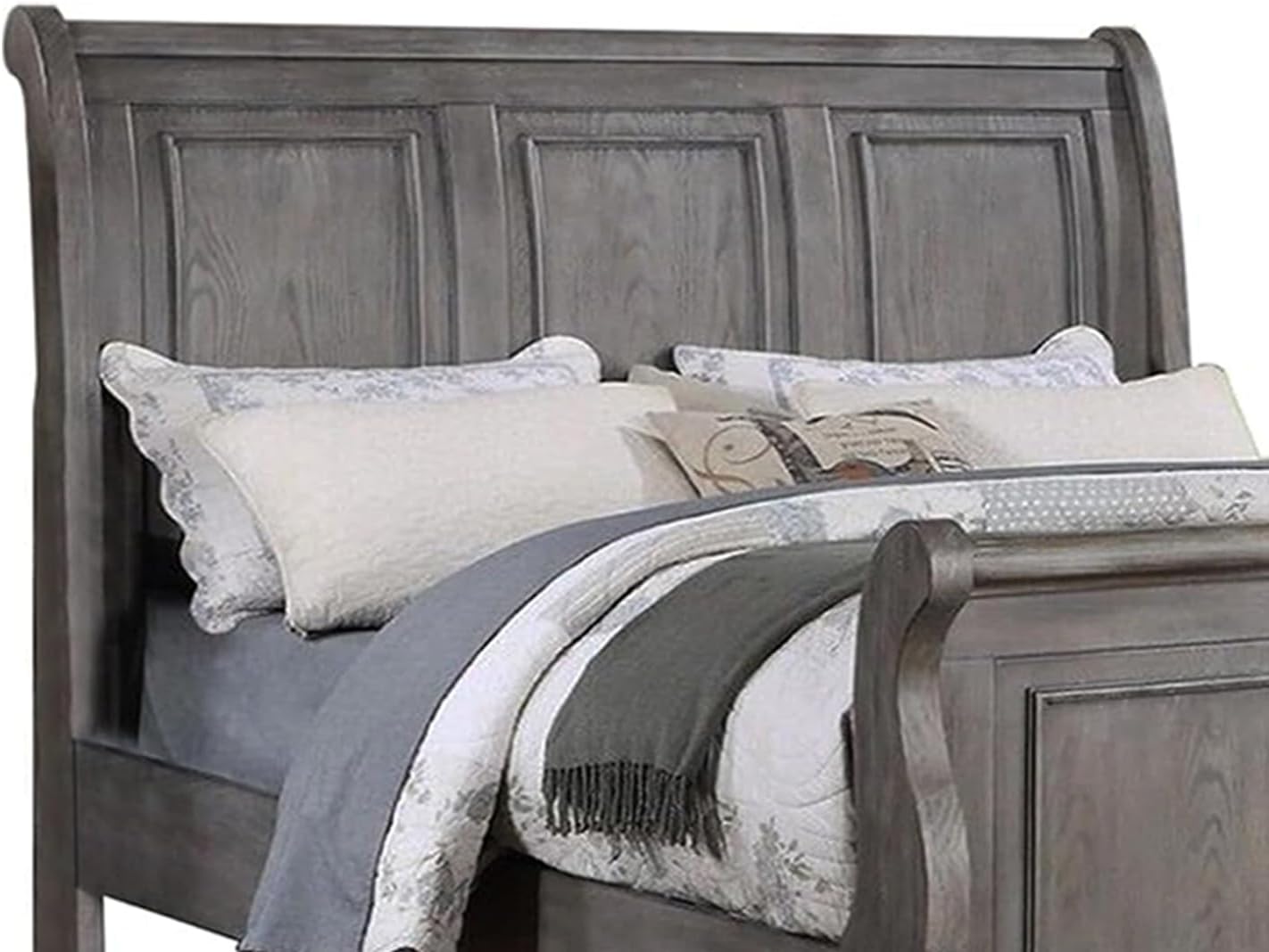Gray wooden sleigh bed with paneled headboard and plush bedding