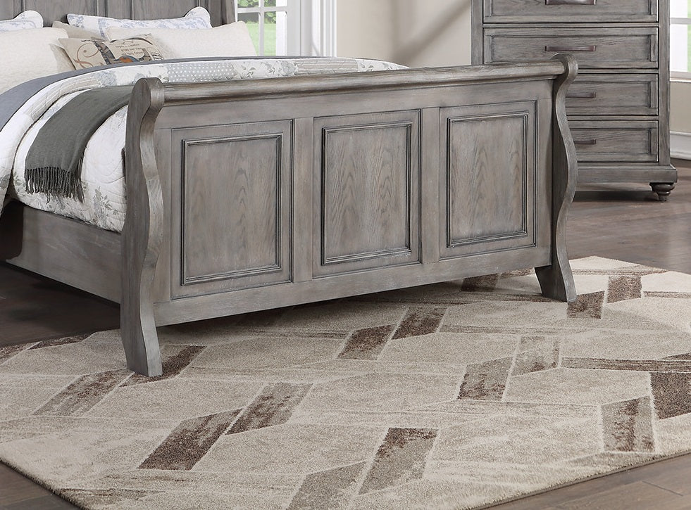Gray wooden sleigh bed frame with paneled headboard part of a bedroom set
