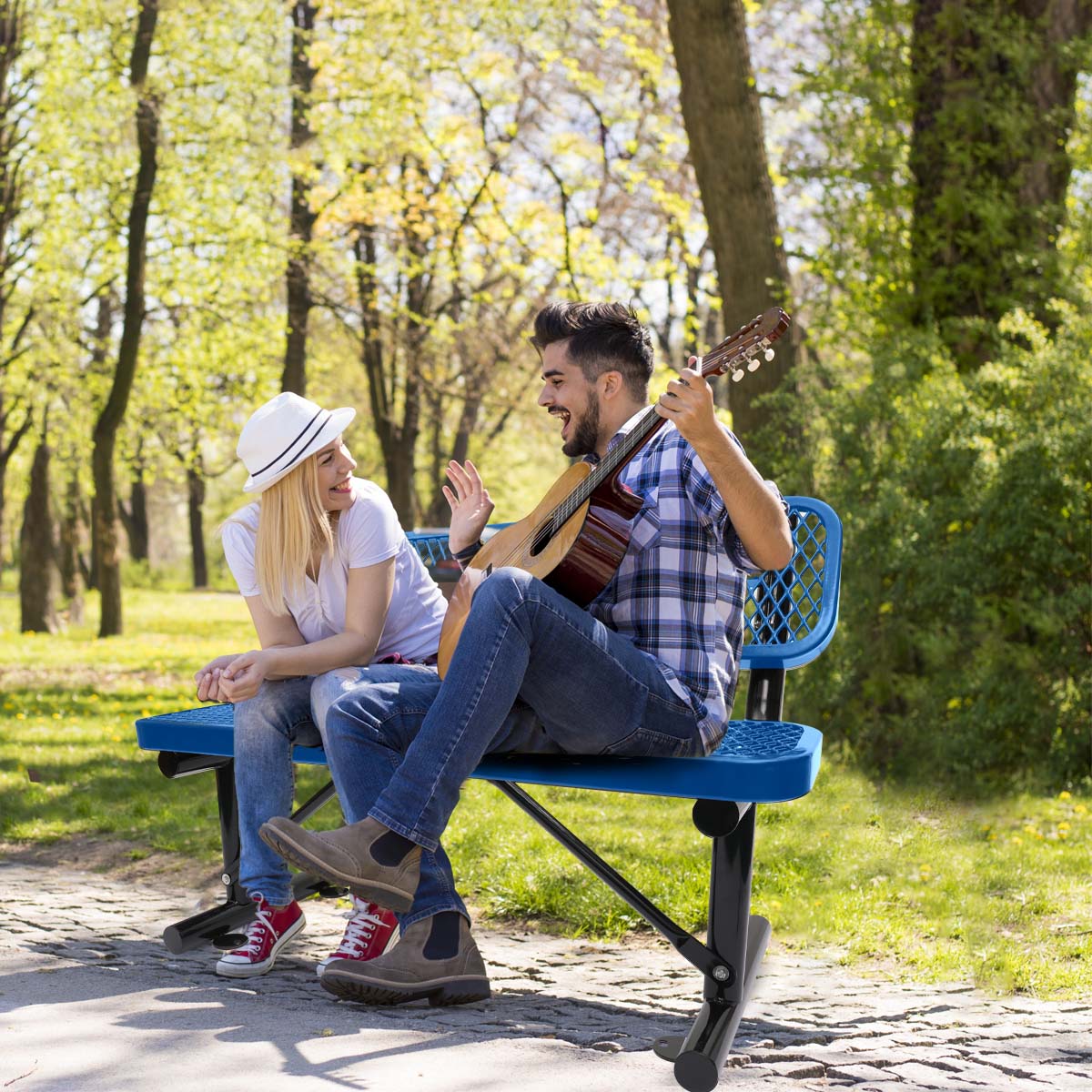 Blue park bench with perforated seat and back supporting a couple enjoying music outdoors