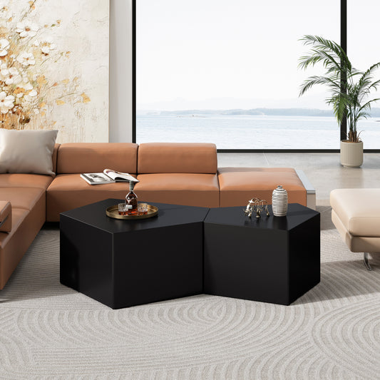 Two modern black geometric nesting coffee tables with a matte finish on a patterned rug