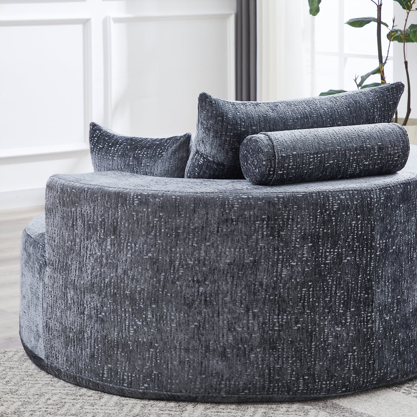 Dark gray textured fabric circular couch with matching bolster pillows