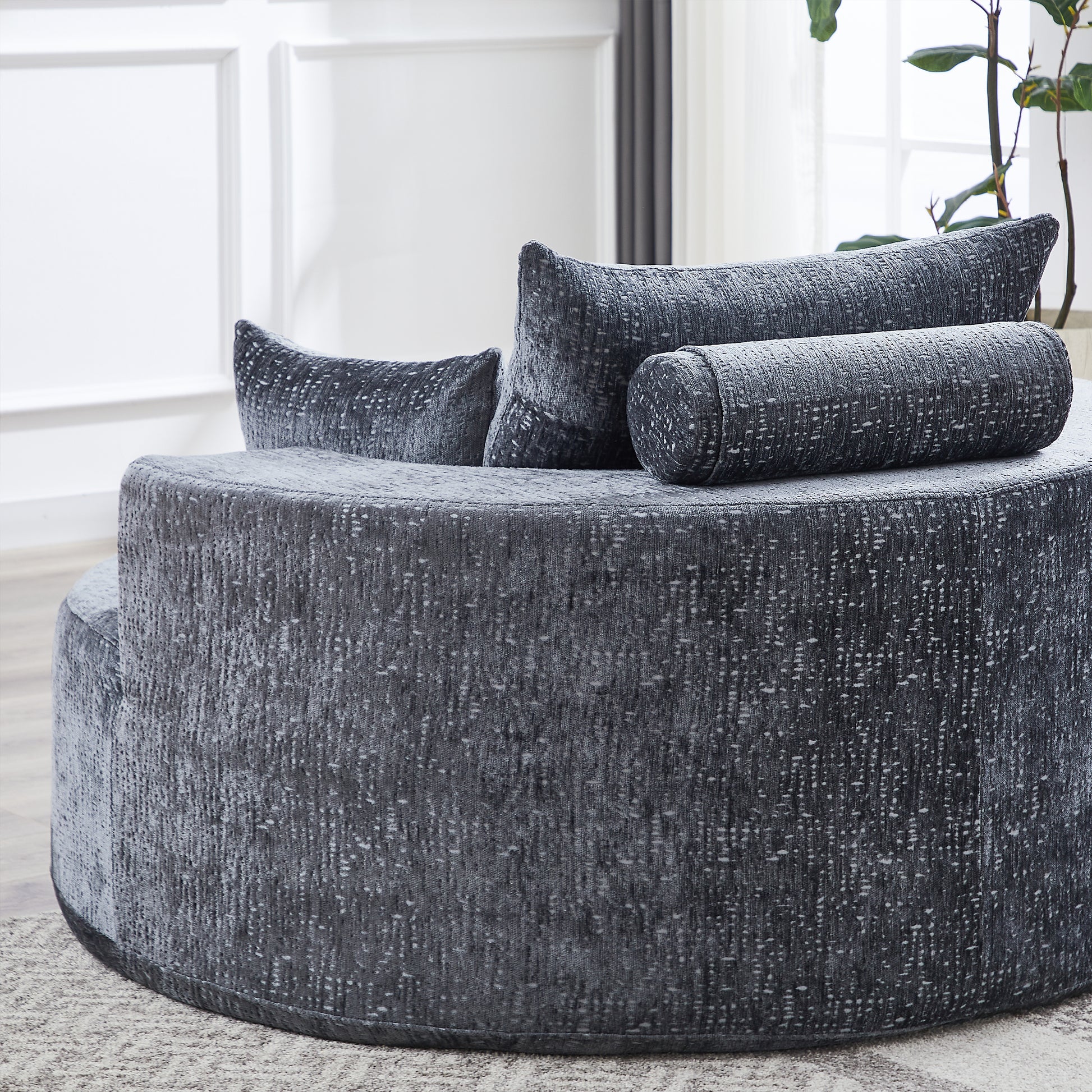 Dark gray textured fabric circular couch with matching bolster pillows
