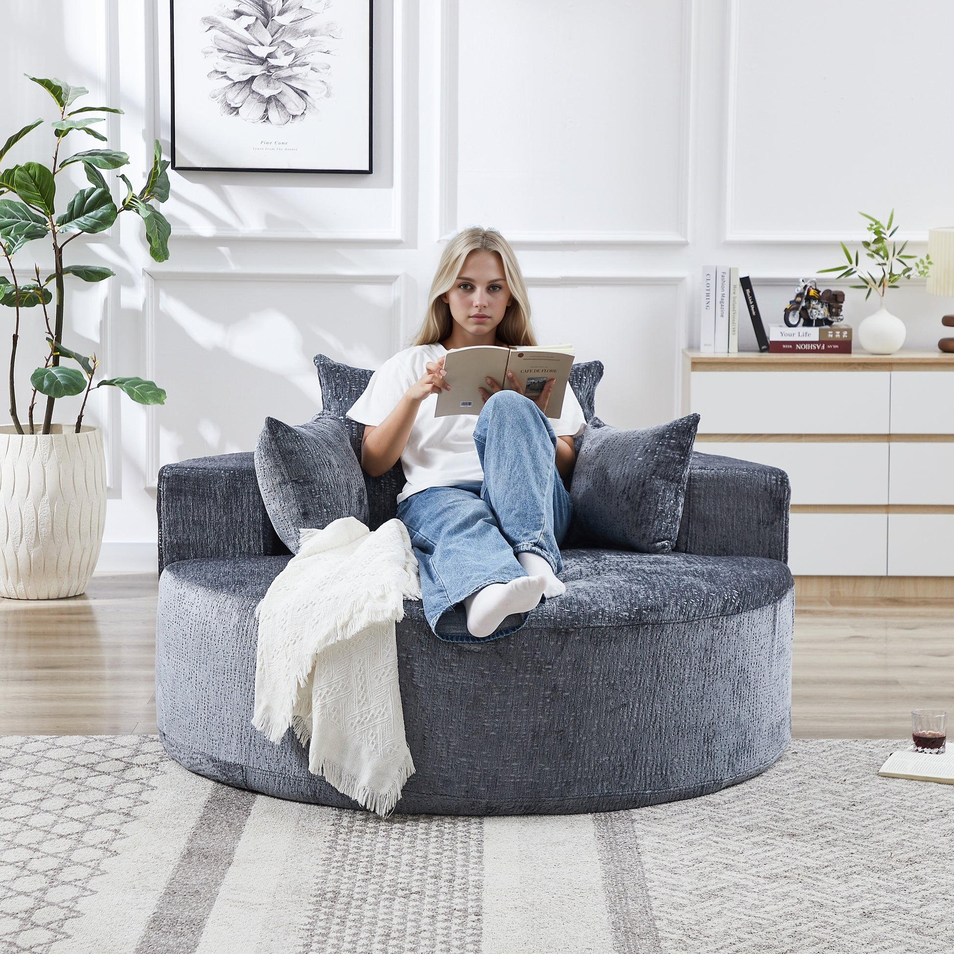 Plush grey swivel barrel chair with textured fabric and matching accent pillows