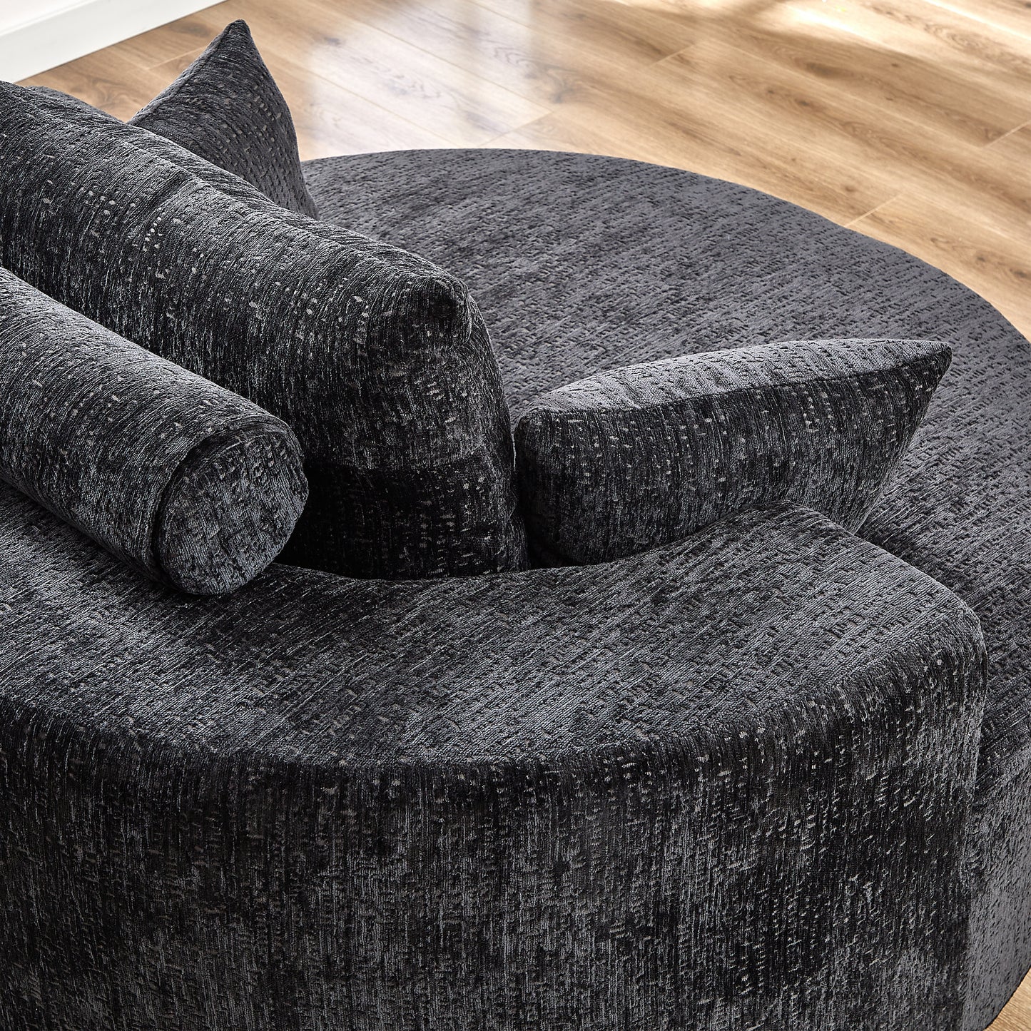 Textured charcoal grey circular sofa with multiple scatter cushions perfect for lounging