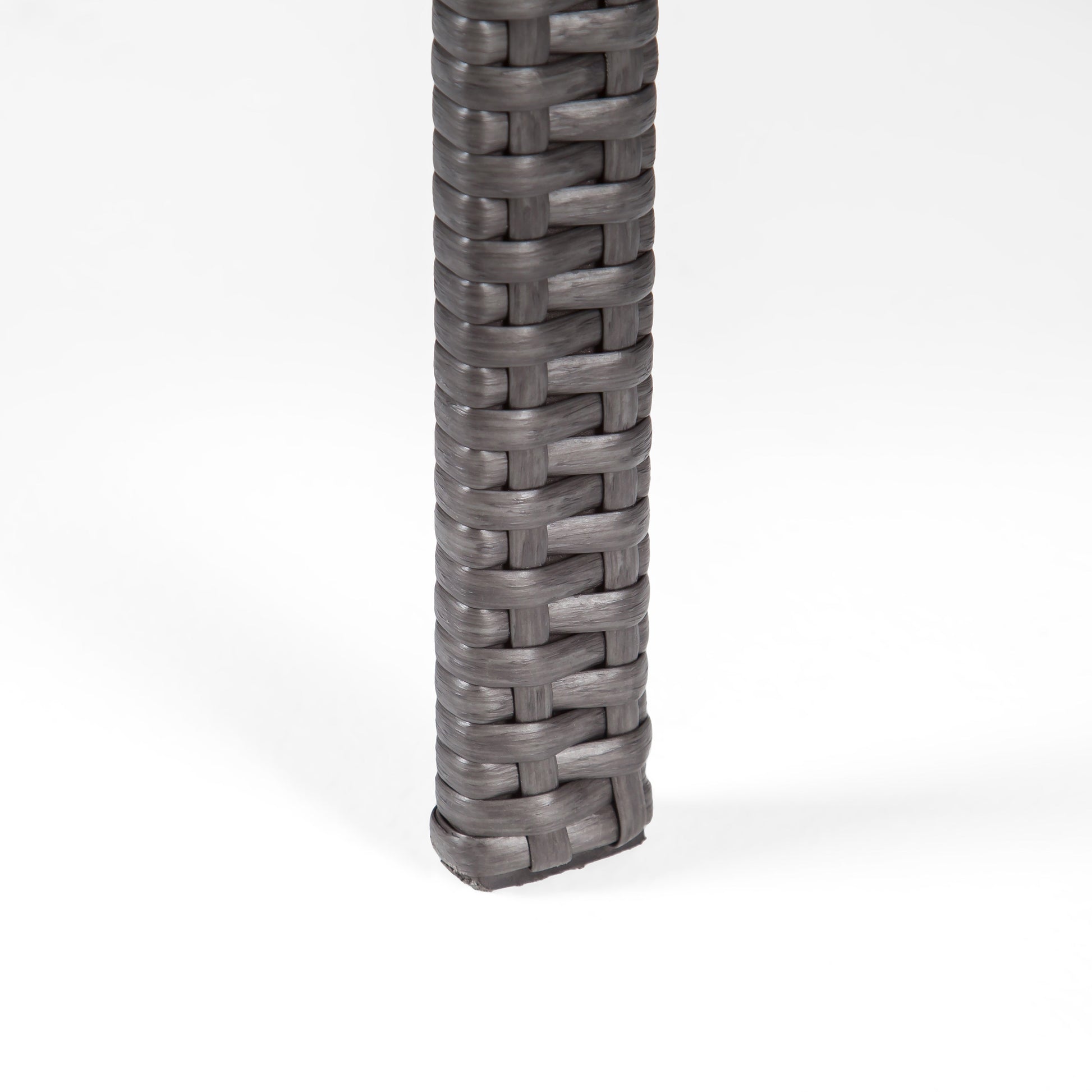 Close up of gray wicker table leg with woven texture
