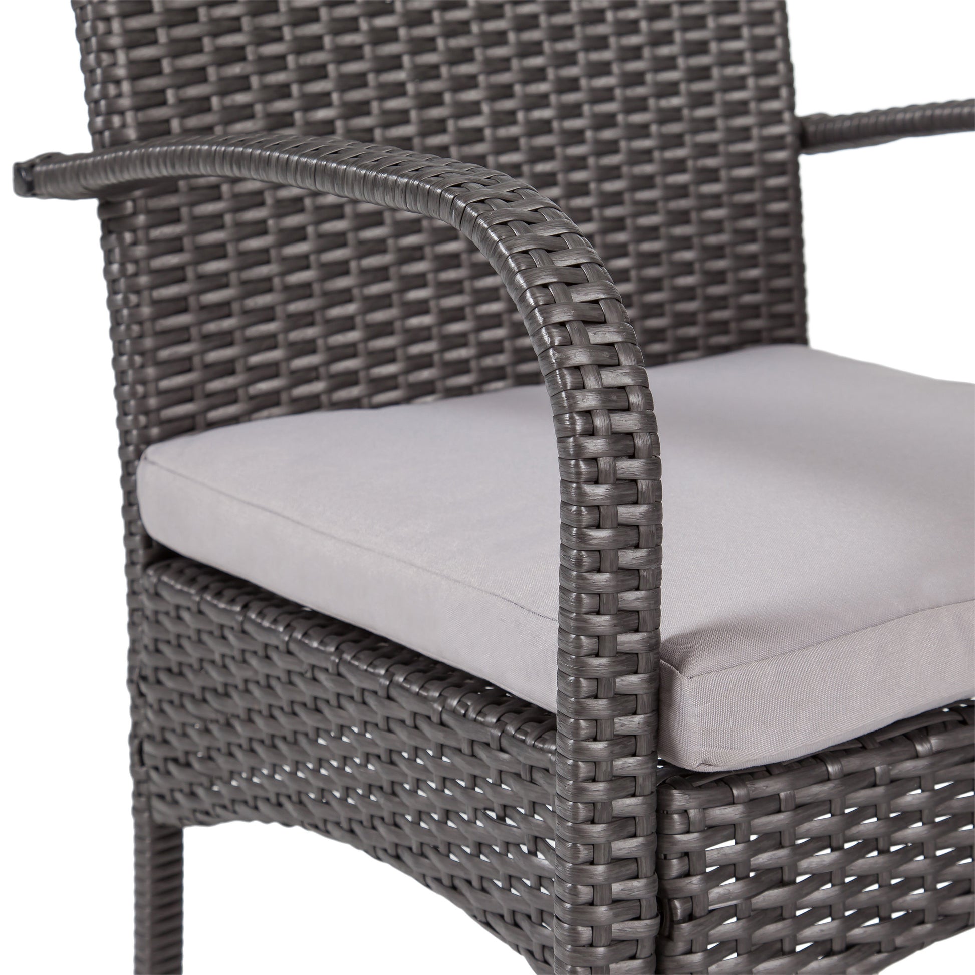 Closeup of a dark grey wicker patio chair armrest with a light grey cushion